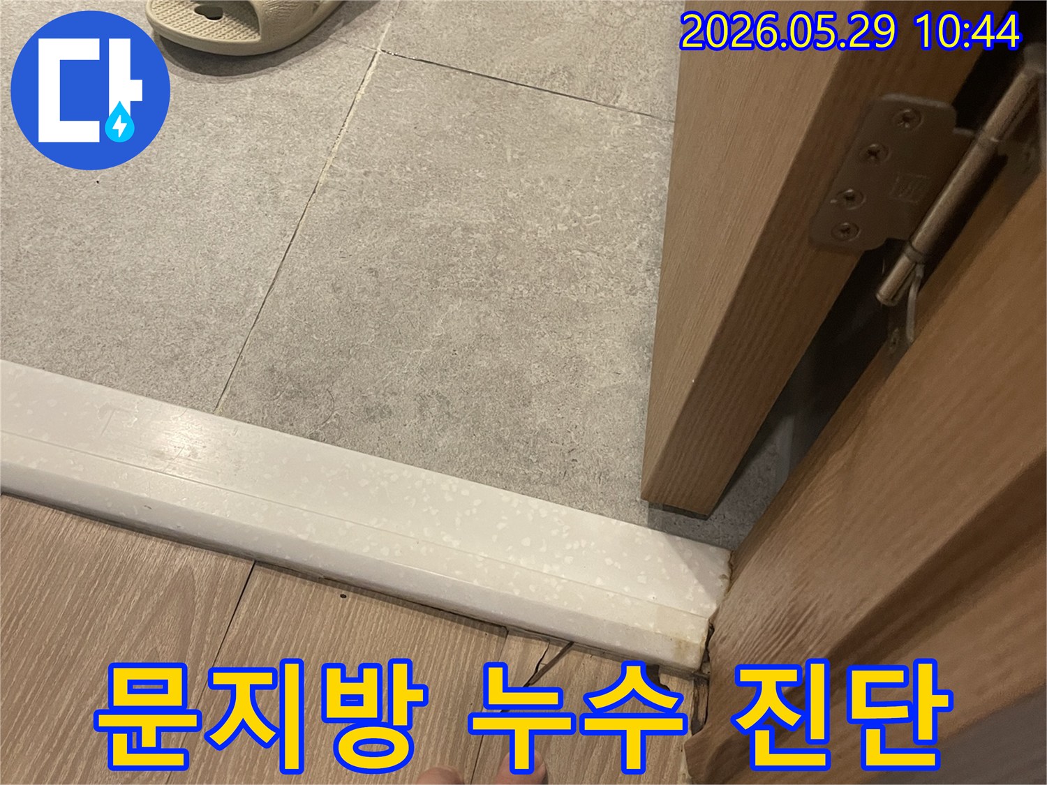 이 사진은 빌라 문지방 주변에서 발생한 누수로 인해-마루 바닥이 손상된 현장을 보여줍니다.