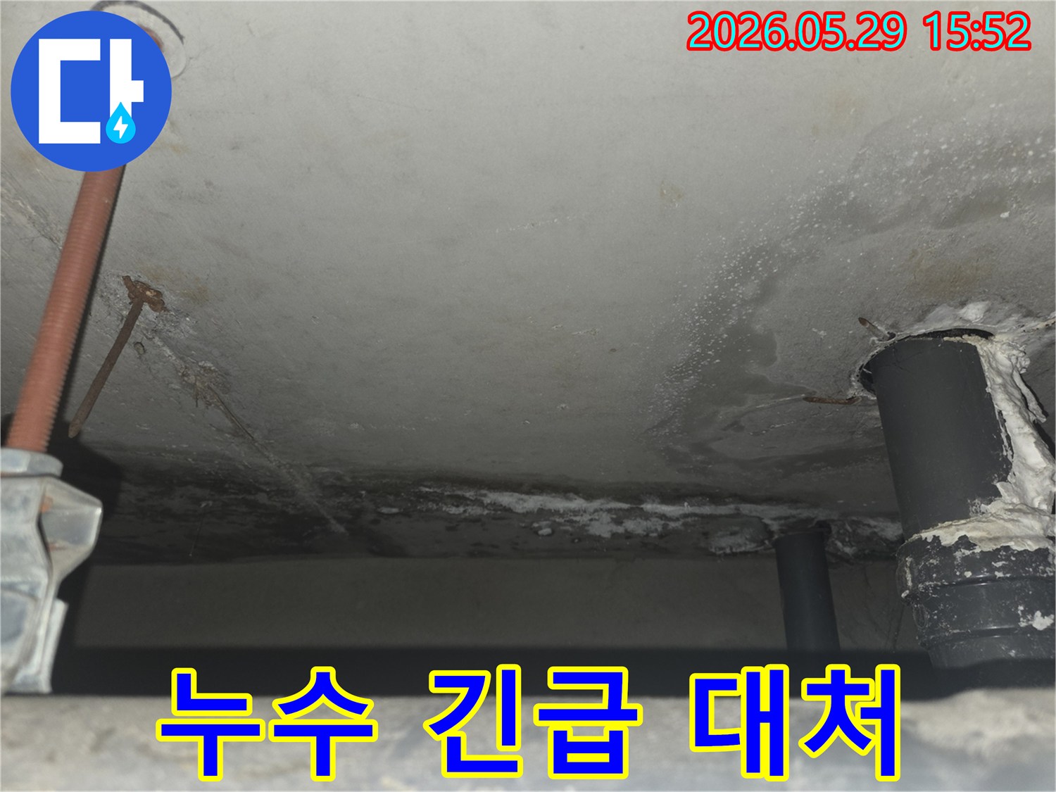 천장 콘크리트에서 물이 새어 떨어지는-긴급한 누수 상황을 보여주며-빠른 대처의 중요성을 강조하는 이미지