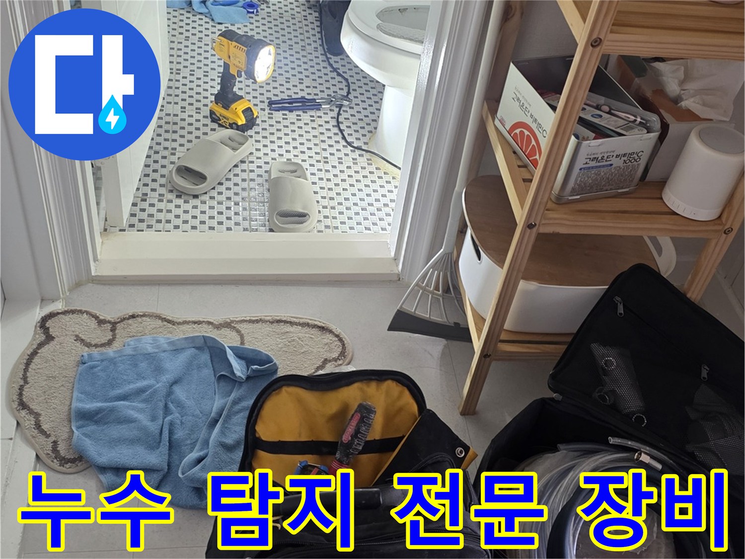 화장실 바닥에 배치된 누수 진단용 공구와 가방
