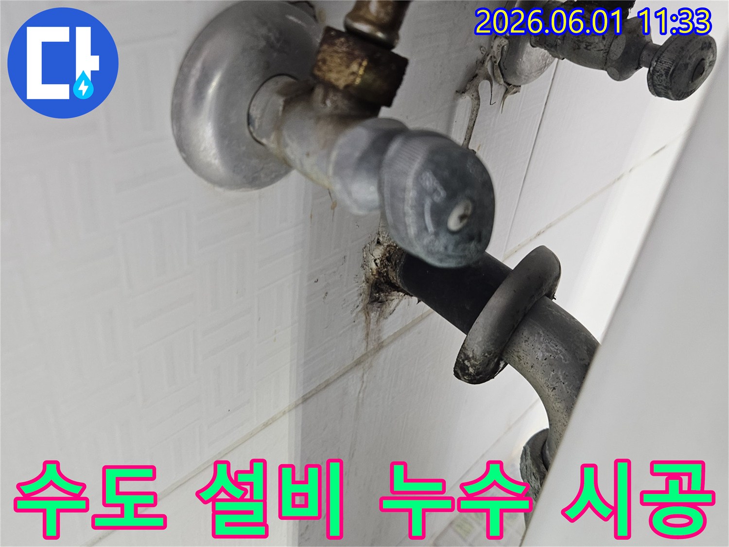 욕실 벽에 설치된 수도 설비의 밸브 주변에서-발생한 물샘과 부식 현장을 촬영한 이미지입니다.