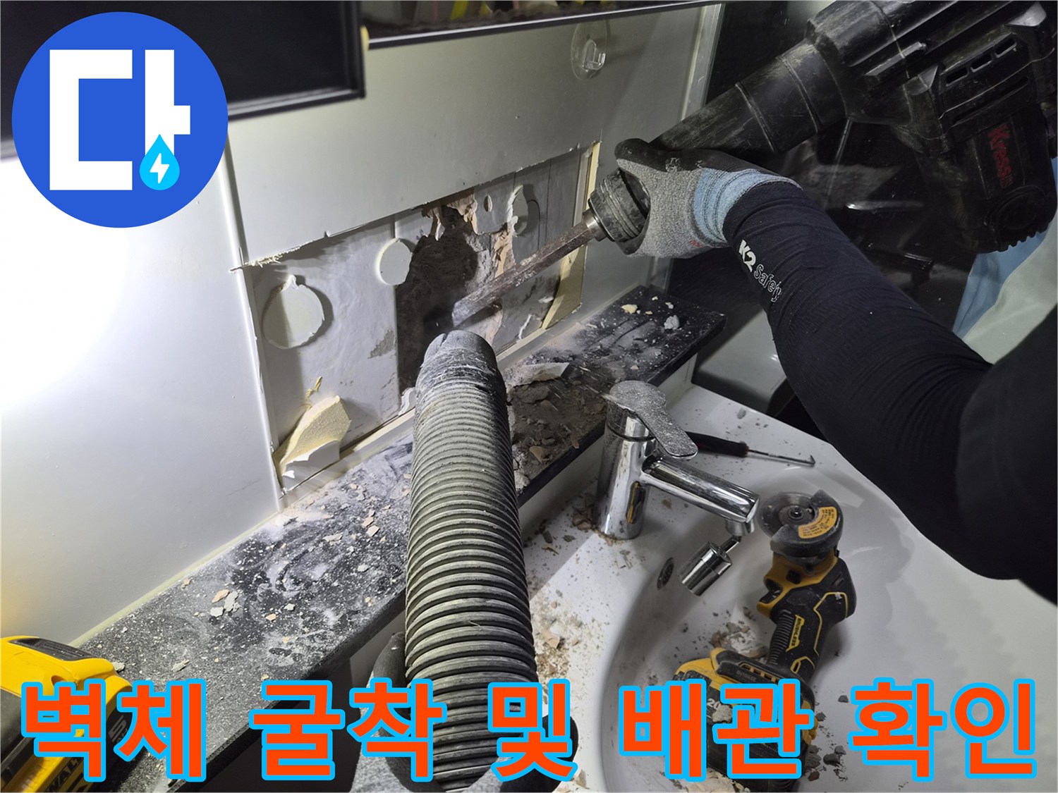 누수 지점을 찾기 위해 화장실 벽면을 파내고 있는 공사 모습