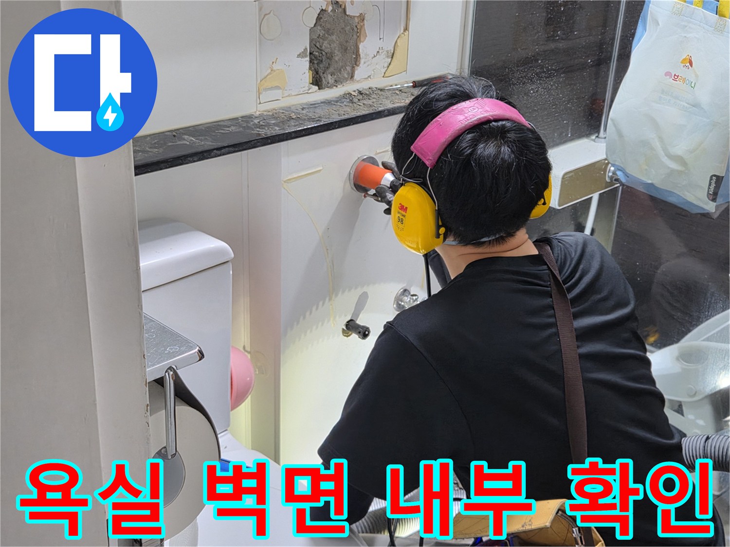 벽면을 제거하여 노출된 배관의 상태를 면밀히 관찰하는 작업자 모습입니다.