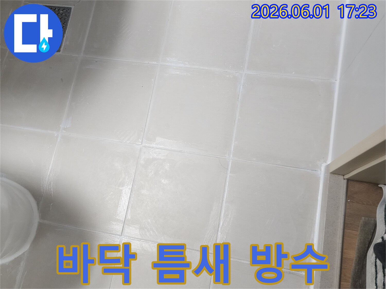 욕실 바닥 타일과-벽면 사이의 틈새에-새로운 방수 재료가-꼼꼼하게 시공되어-누수를 방지하는-모습을 보여줍니다.