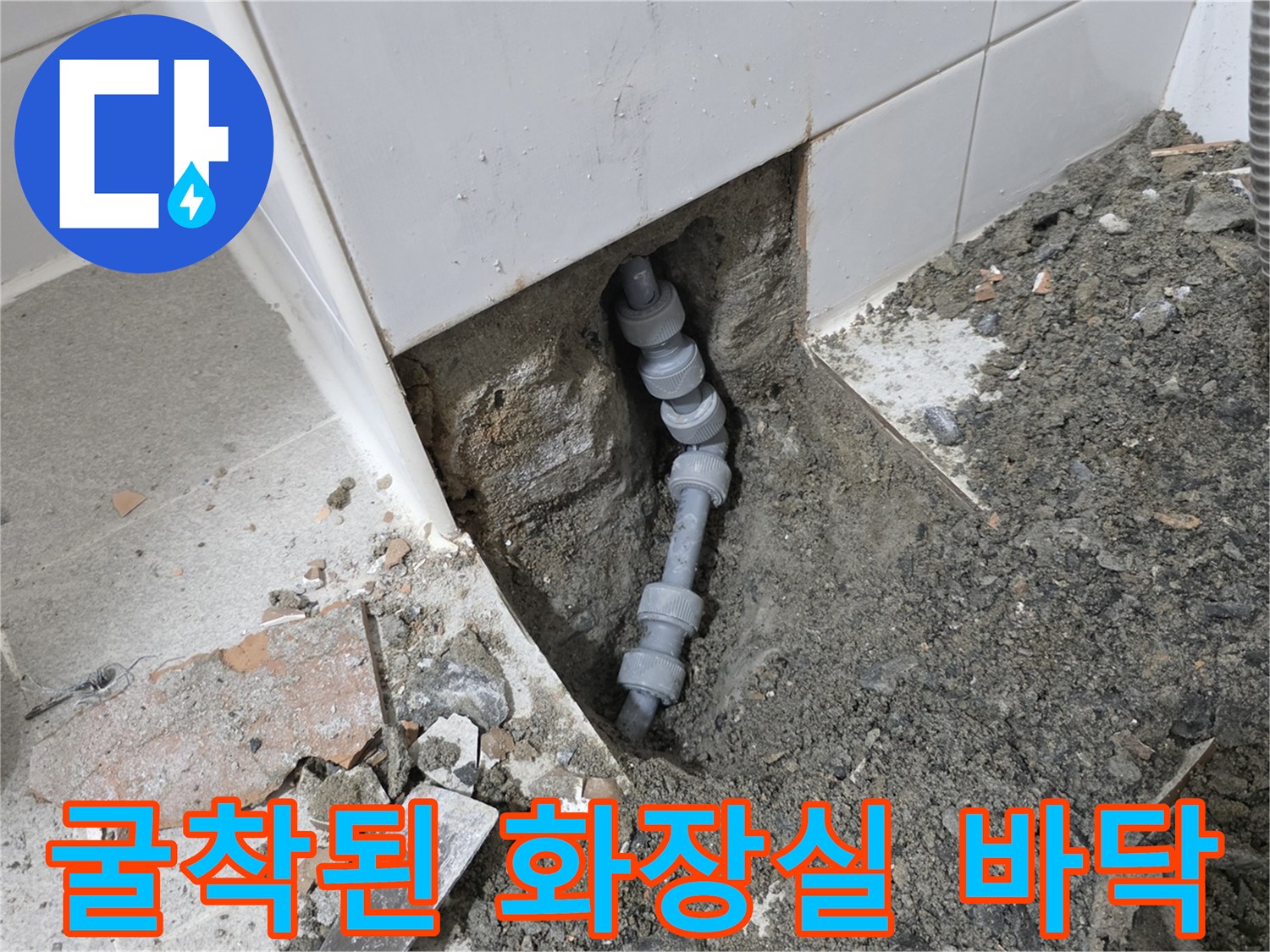 타일을 제거하고 배관 상태를 점검 중인 현장 사진입니다.