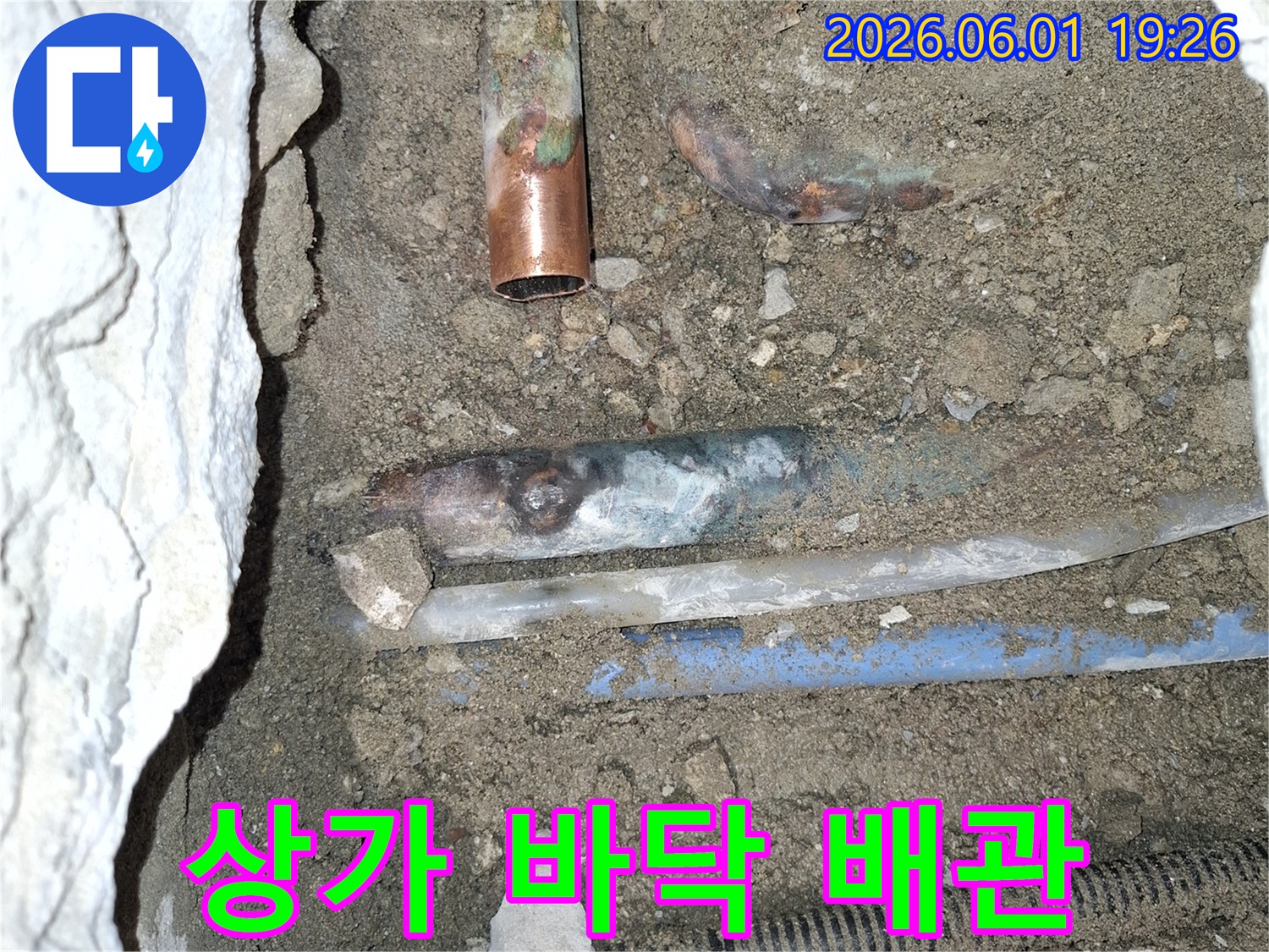 상가-건물-바닥-아래-묻힌-배관에서-누수가-발생하여-땅을-파내어-손상된-배관을-확인하는-모습입니다