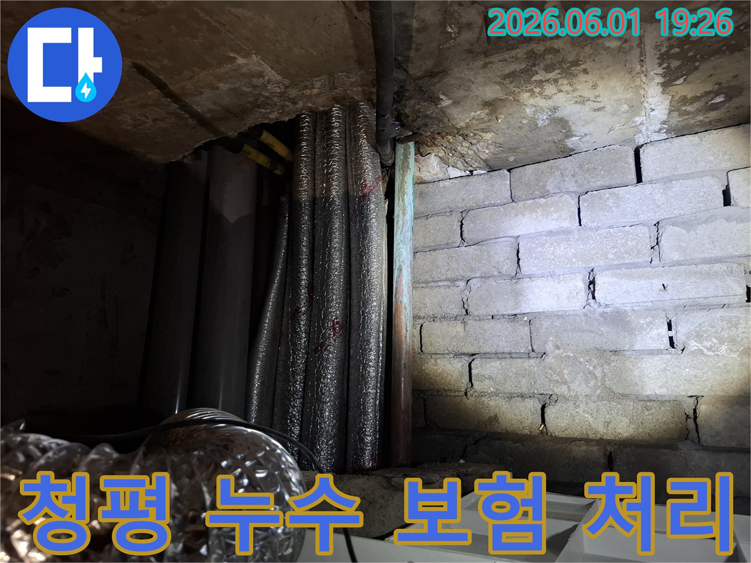 어두운 지하 공간에서-천장 배관과-벽돌 벽면의-누수 흔적을-확인하는 모습의-누수탐지 현장 사진입니다