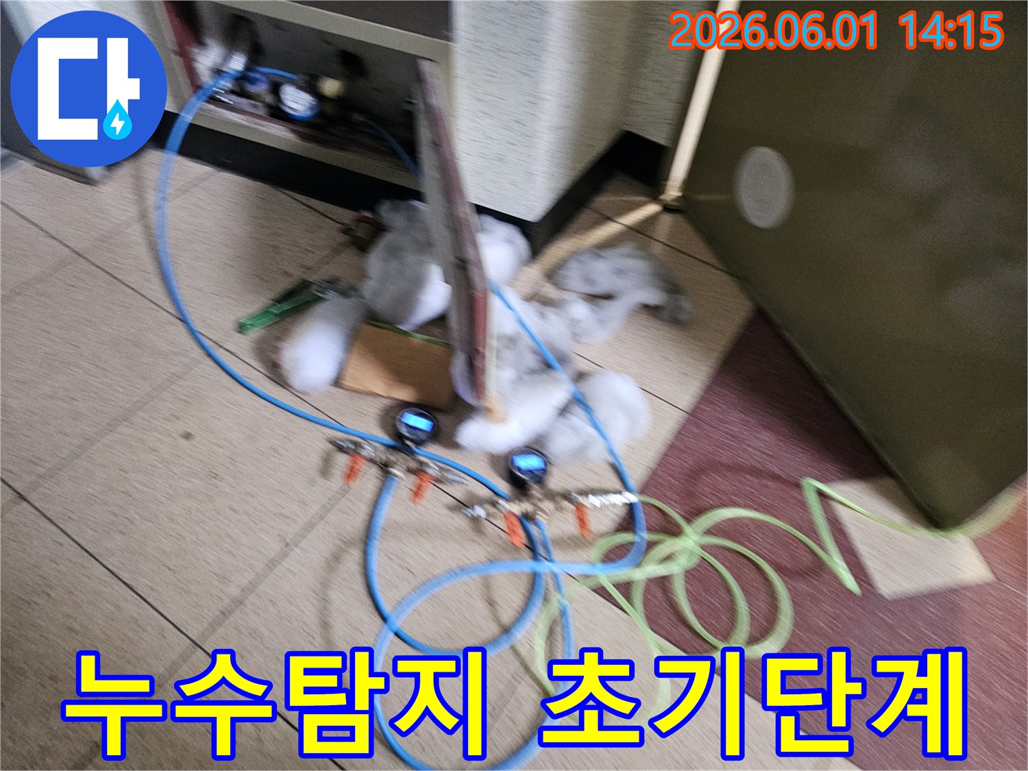 누수 지점을 찾기 위해 압력 게이지가 연결된 파란색 호스 장비