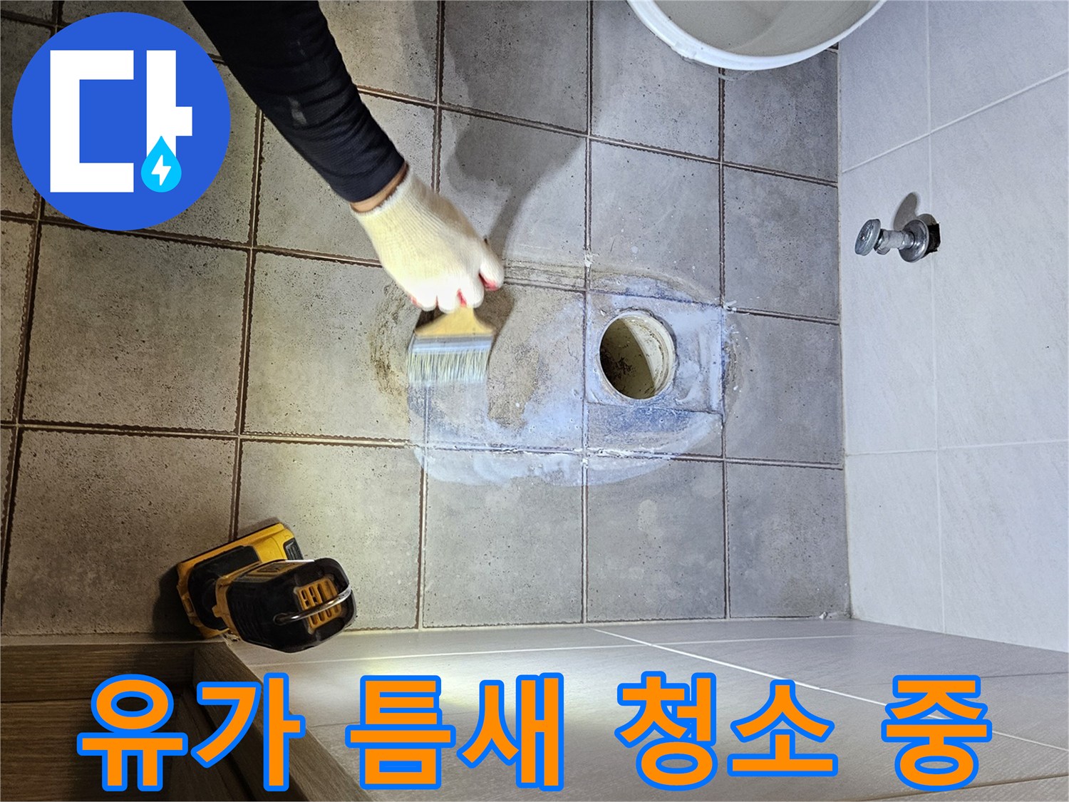 브러쉬로 배수구 주변의 오염된 잔여물을 제거하는 모습입니다.
