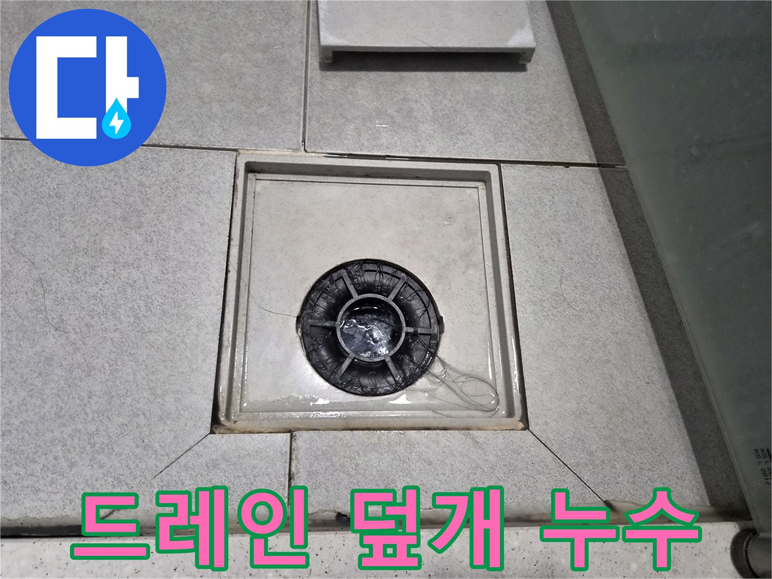 욕실 바닥의 배수구 덮개 주변에 물기가 고여있고-누수 가능성을 보여주는 흔적이 있습니다.
