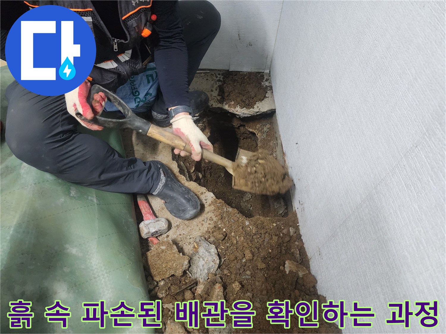 삽으로 흙을 걷어내고 매립된 수도관의 이상 부위를 점검함