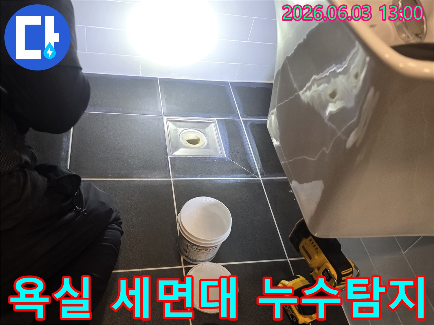 욕실 세면대 아래에서 누수 흔적을 확인하고-정밀 탐지를 위해 준비하는 모습입니다