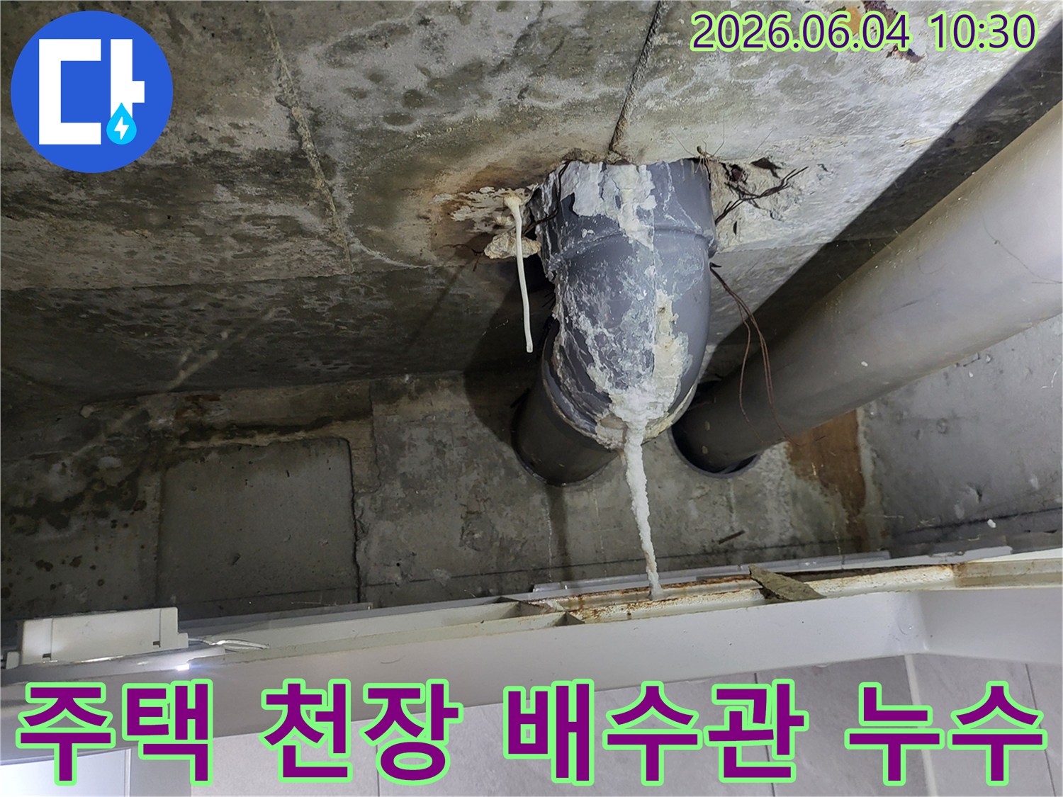 천장 콘크리트와 배수관 연결 부위에서-물이 새어 하얀 석회질이 길게 형성된 모습