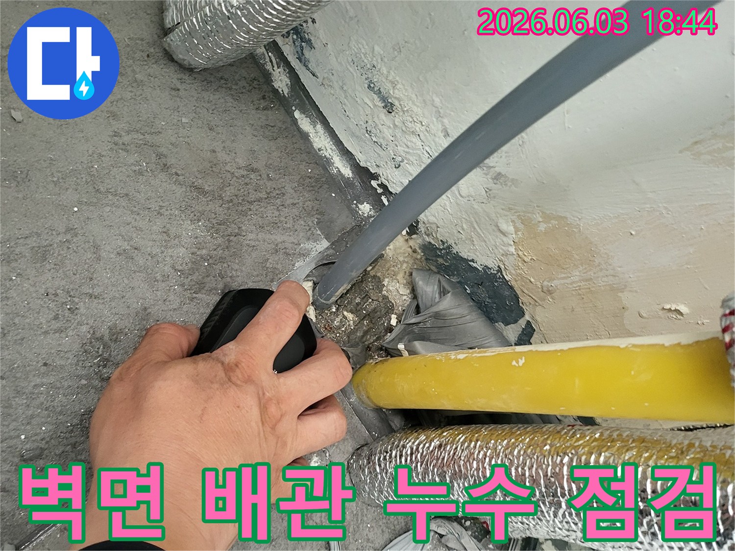벽면-하단의-배관에서-발생한-누수를-전문-탐지기로-세밀하게-점검하는-현장-모습입니다.