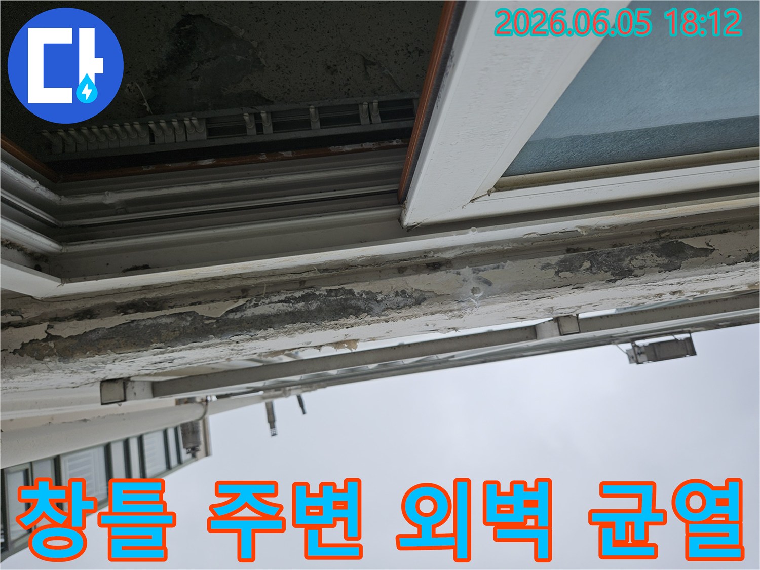 건물 외벽 창틀 상단부의 페인트 손상과 잠재된 균열-빗물이 스며들어 내부로 침투할 위험이 높은 상태-균열 보수 및 방수 처리가 시급한 상황
