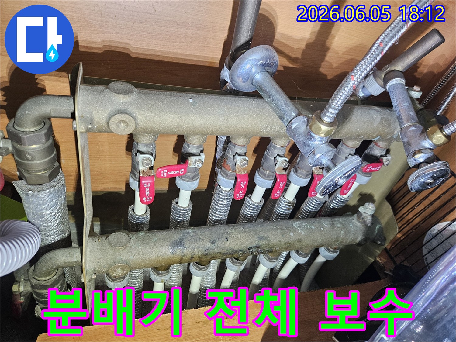 난방 분배기의 모든 배관과 밸브-누수 여부를 전체적으로 점검하고-필요한 보수 작업을 진행하는 모습