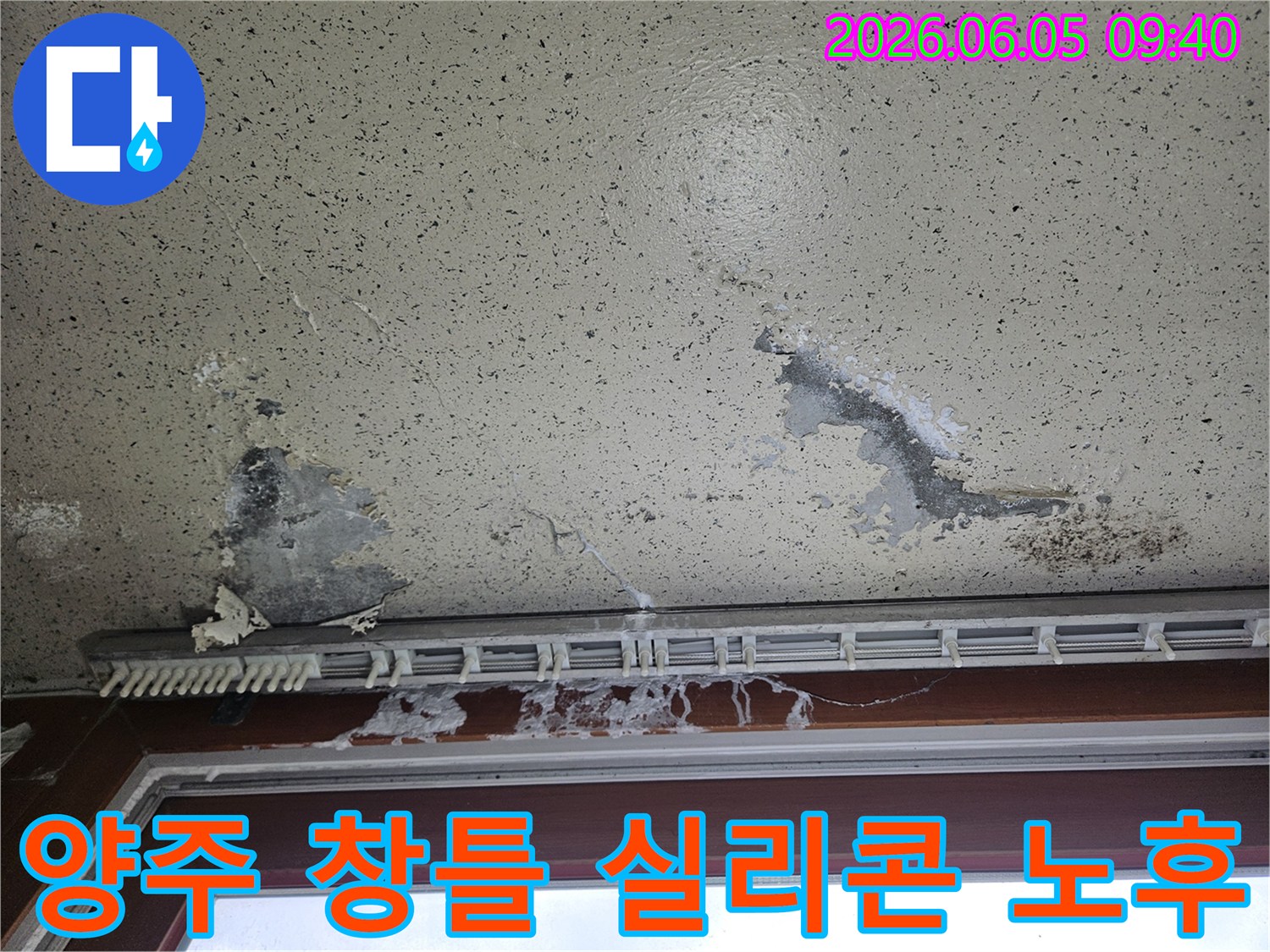 주택 창틀 주변 벽지가 물에 젖어 변색되고-곰팡이가 피어난 모습으로-창틀 실리콘 노후로 인한 빗물 유입 누수 피해를 보여줍니다.