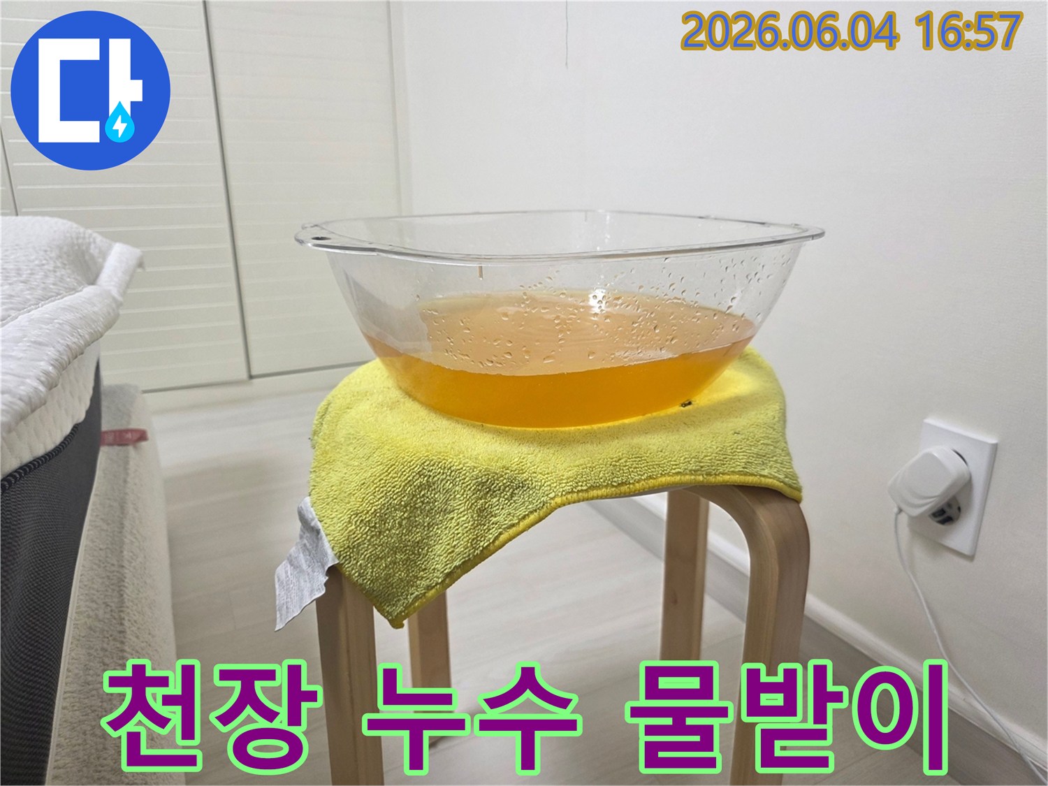 누수로 인해 천장에서 떨어지는 물을-안전하게 받아내기 위해-설치된 임시 물받이의 모습