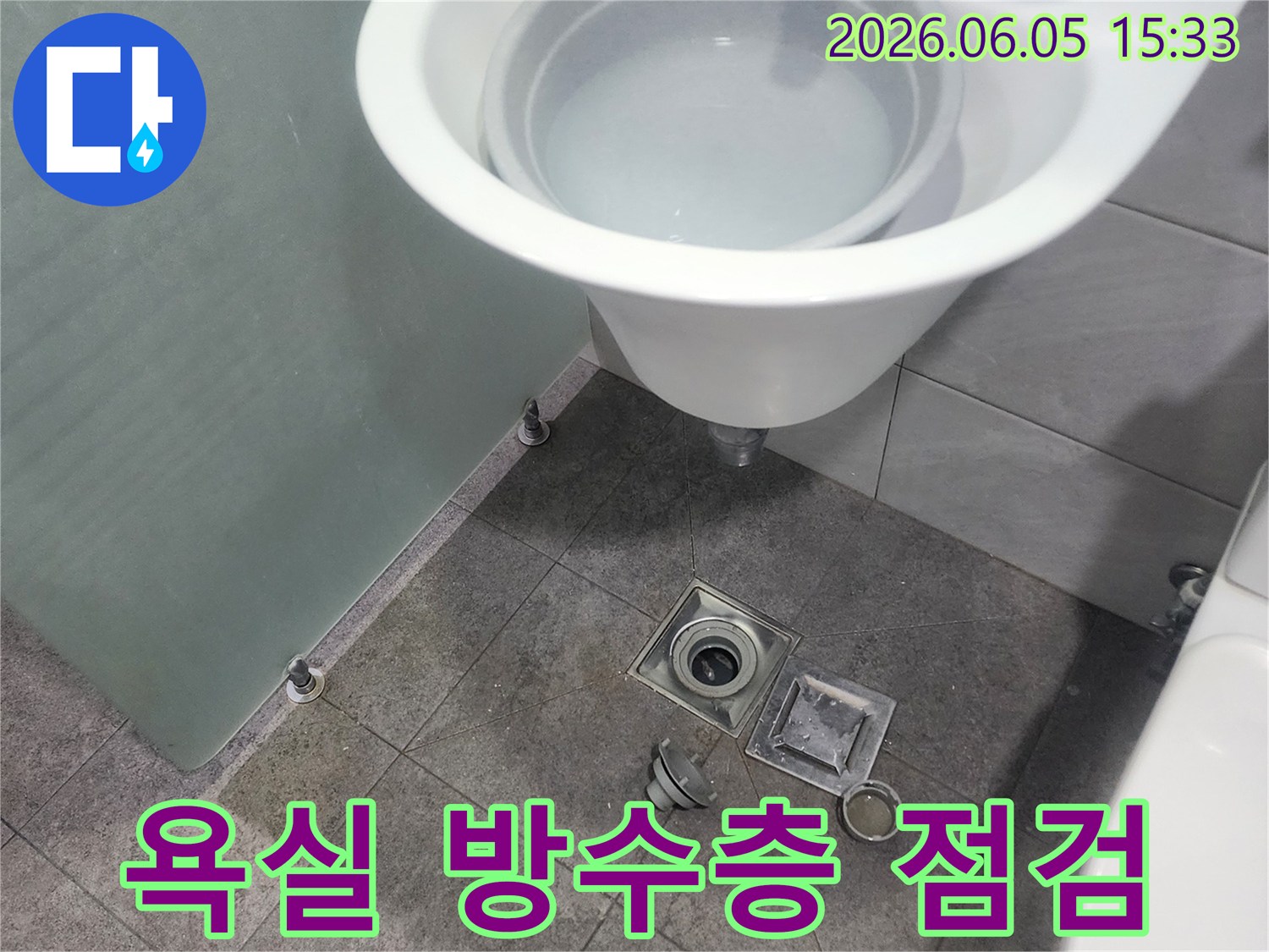 누수-엔지니어가-욕실-바닥-배수구-주변-방수층-손상-여부를-확인하기-위해-점검하는-과정을-담은-사진