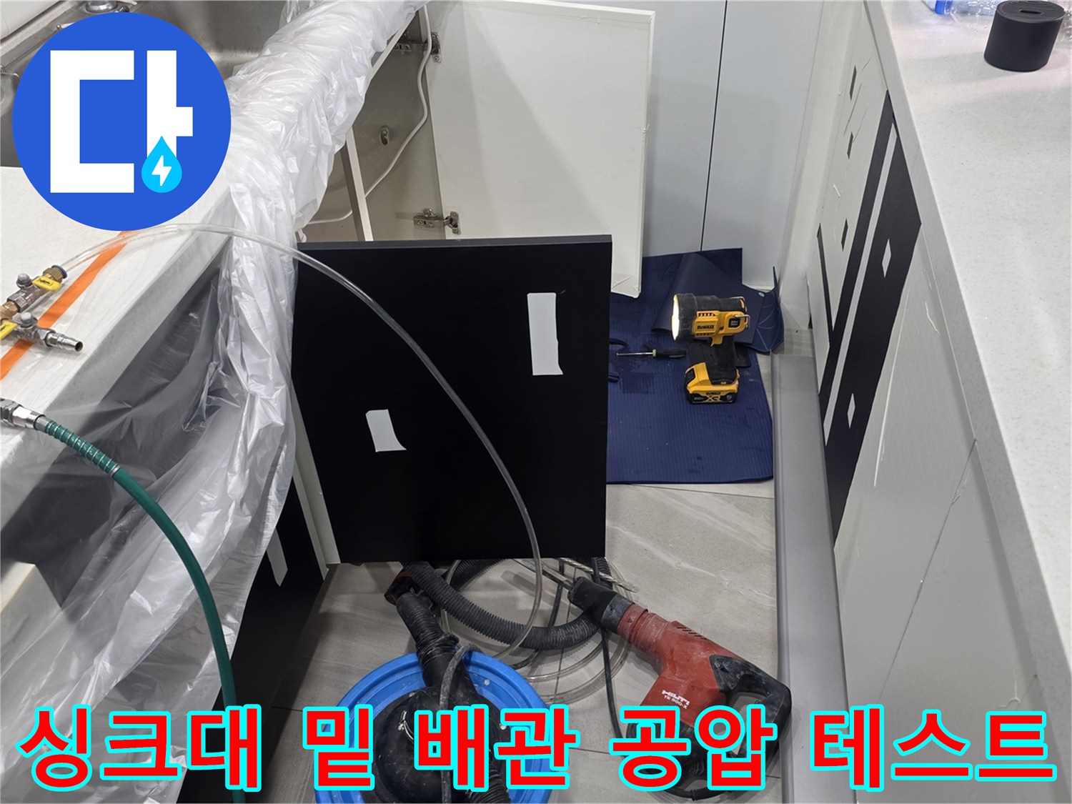 싱크대 하부 배관에 연결된 압력 측정 장비와 호스들