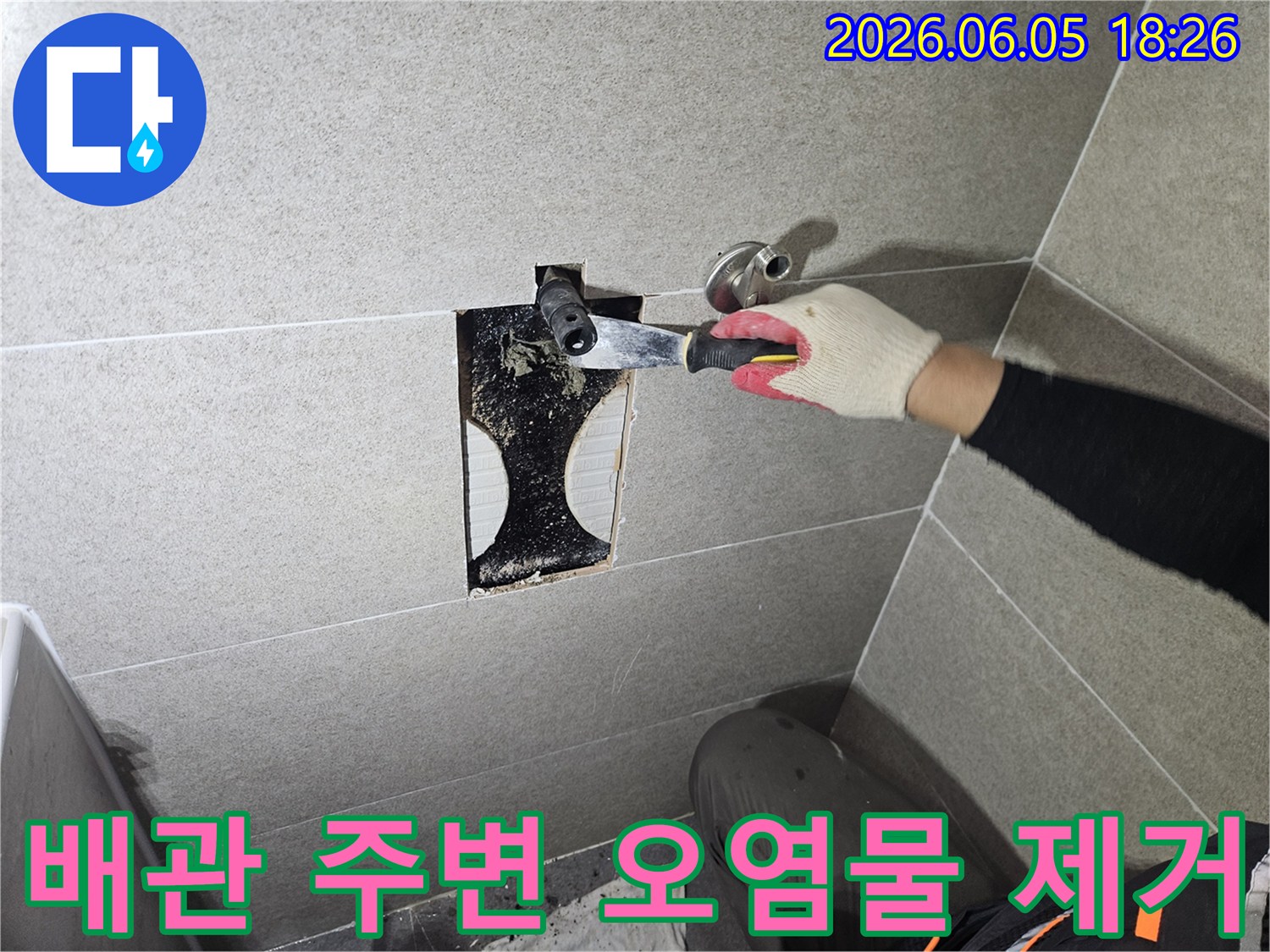 숙련된 엔지니어가-누수 원인 파악을 위해-벽면 내부의-오염된 배관 주변을-세심하게 청소하는-모습을 담고 있습니다.