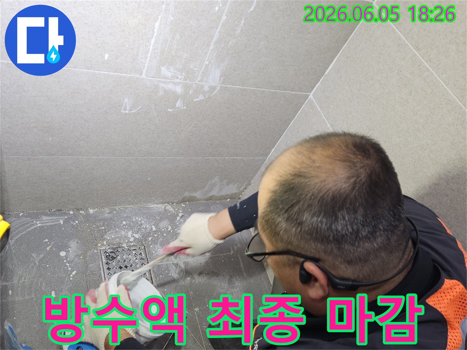 전문 기술자가 화장실 바닥 방수 작업을 최종 마감하며-타일 틈새를 깔끔하게 정리하여 완벽한 방수층을 완성하고 있습니다
