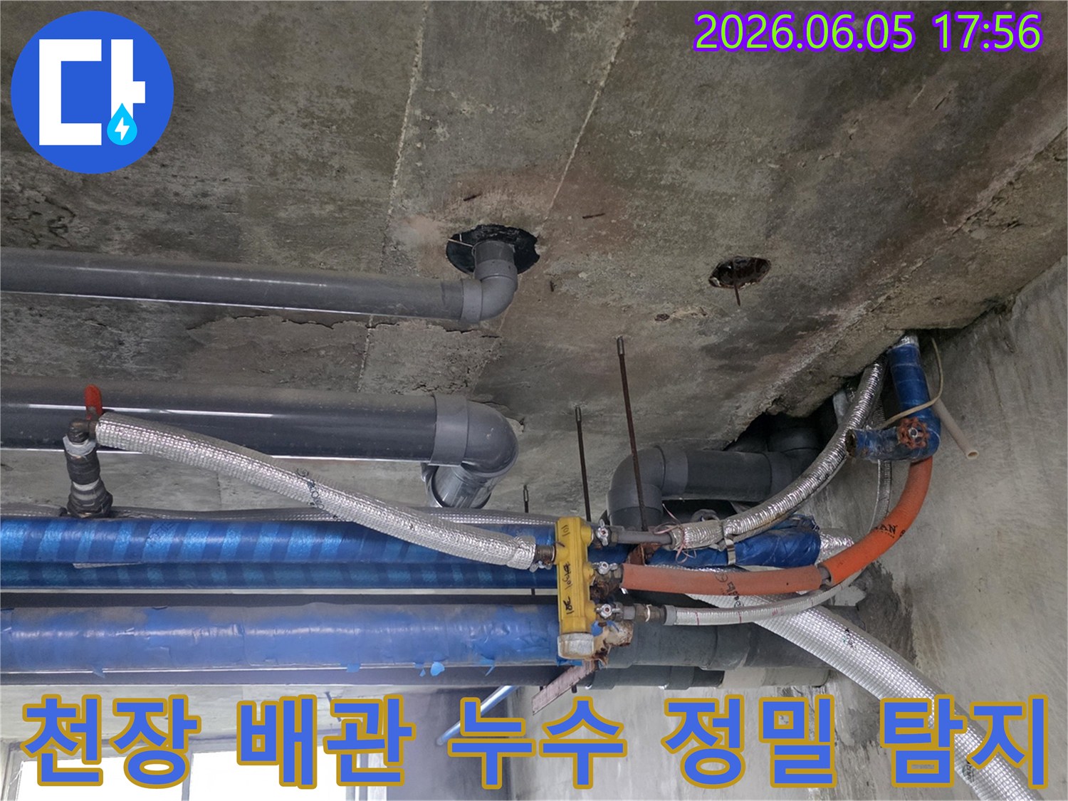 콘크리트-천장-아래-설치된-다양한-배관들의-복잡한-모습-누수-탐지-전문가가-현장을-면밀히-조사하고-있습니다