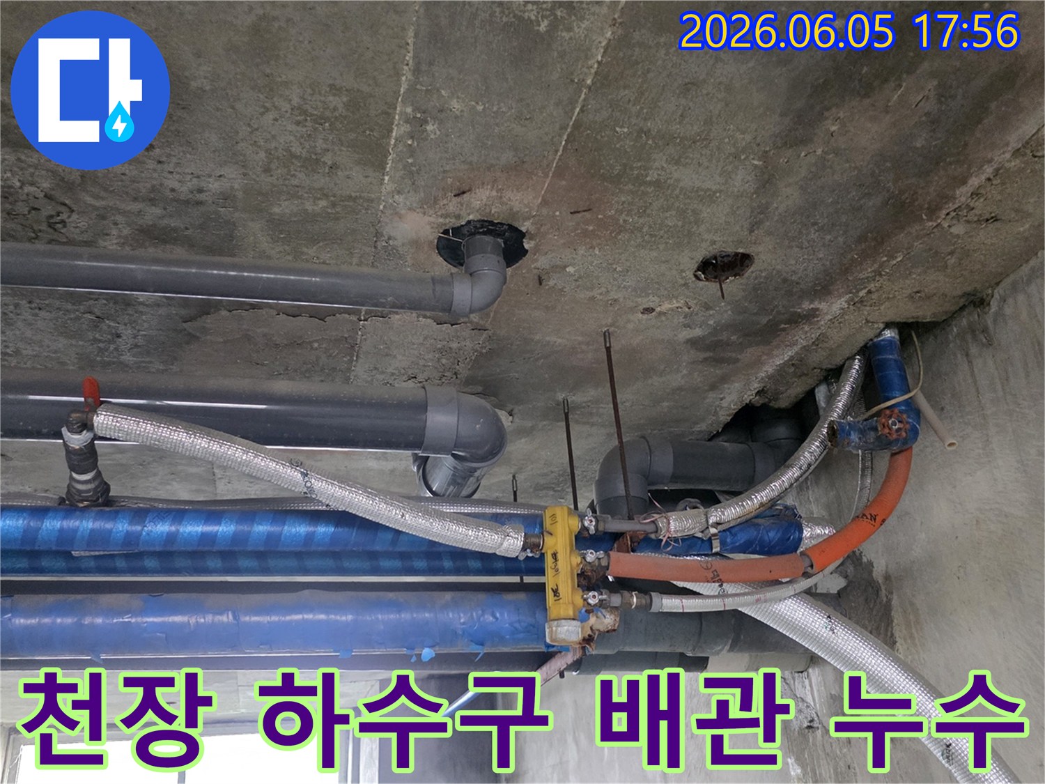 콘크리트-천장-아래-설치된-다양한-배관들의-복잡한-모습-누수-탐지-전문가가-현장을-면밀히-조사하고-있습니다