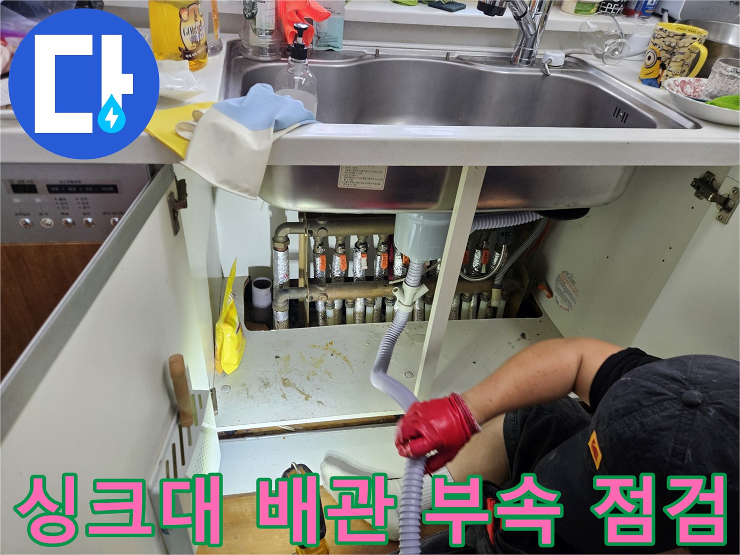 싱크대 하부 공간의 금속제 분배기와 엑셀 파이프 연결 부위를 육안으로 확인하는 장면