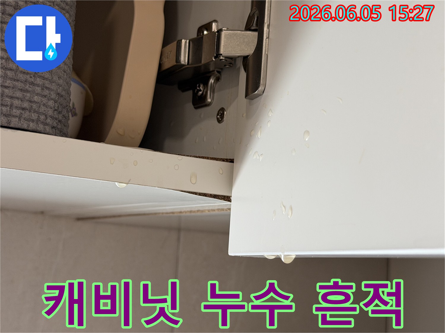 주방 캐비닛에서 물방울이 떨어지는-누수 현장을 명확히 보여주는 사진입니다.