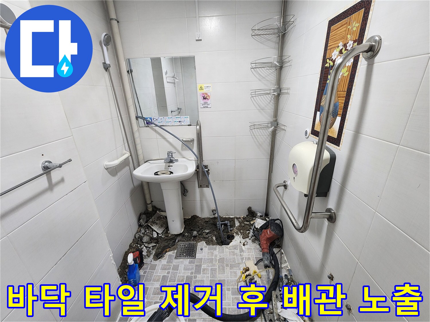 욕실 바닥 굴착을 통해 드러난 파손된 매립 배관과 작업 장비