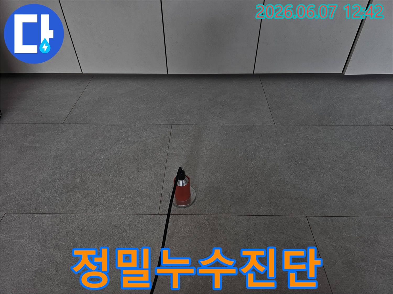 숙련된-기술자가-누수-원인을-찾기-위해-음향-탐지-작업을-진행하는-모습