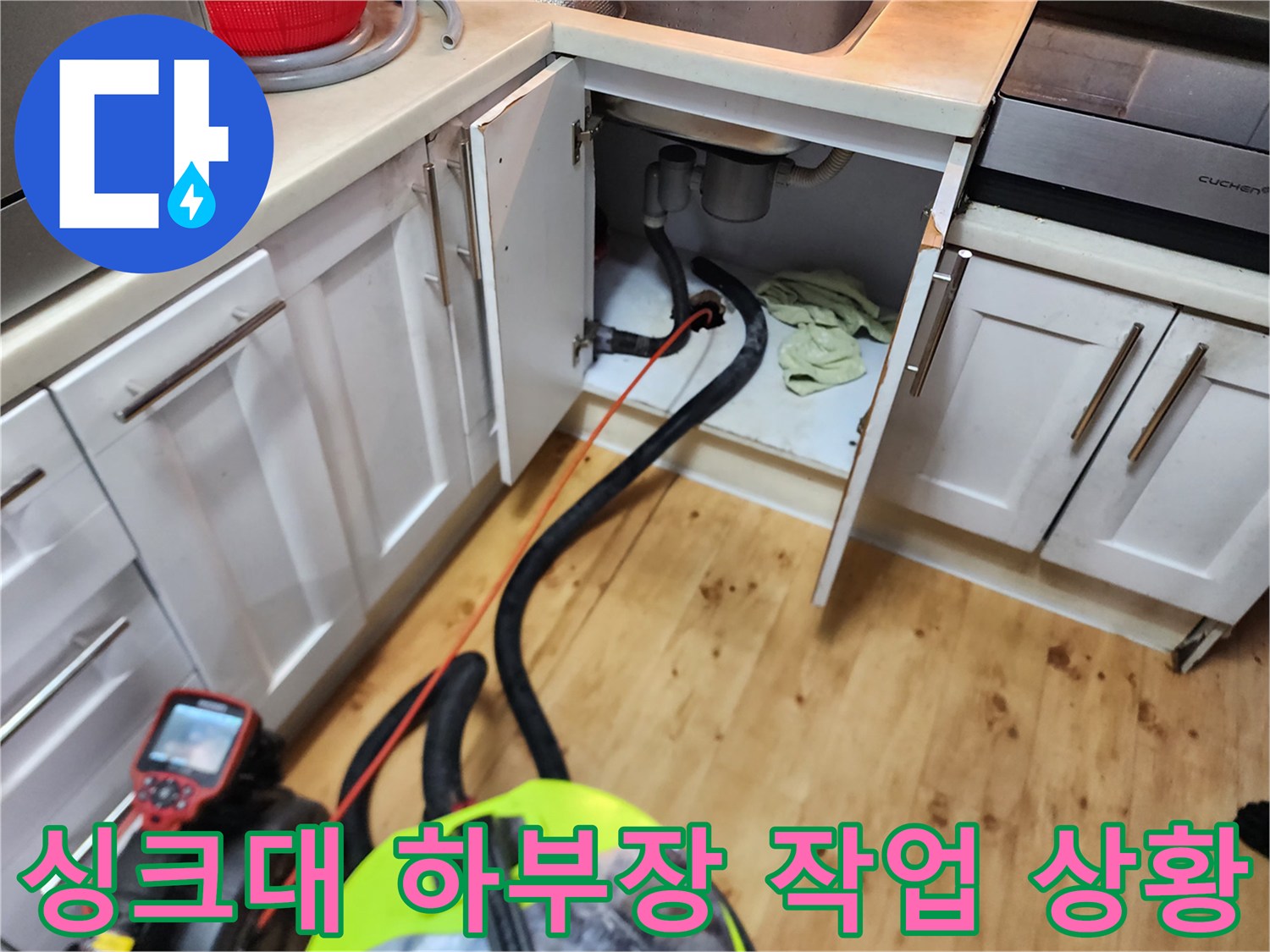 싱크대 밑 배수 호스와 석션 장비가 연결되어 작동하는 장면입니다.