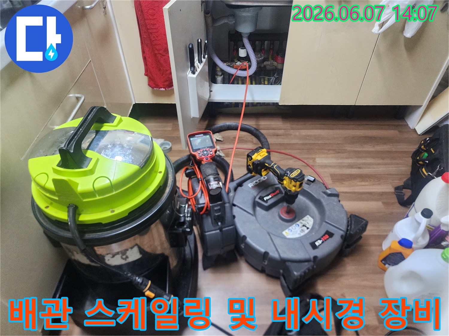 싱크대 하부 배관 작업을 위한 전문 장비와 측정 도구 배치