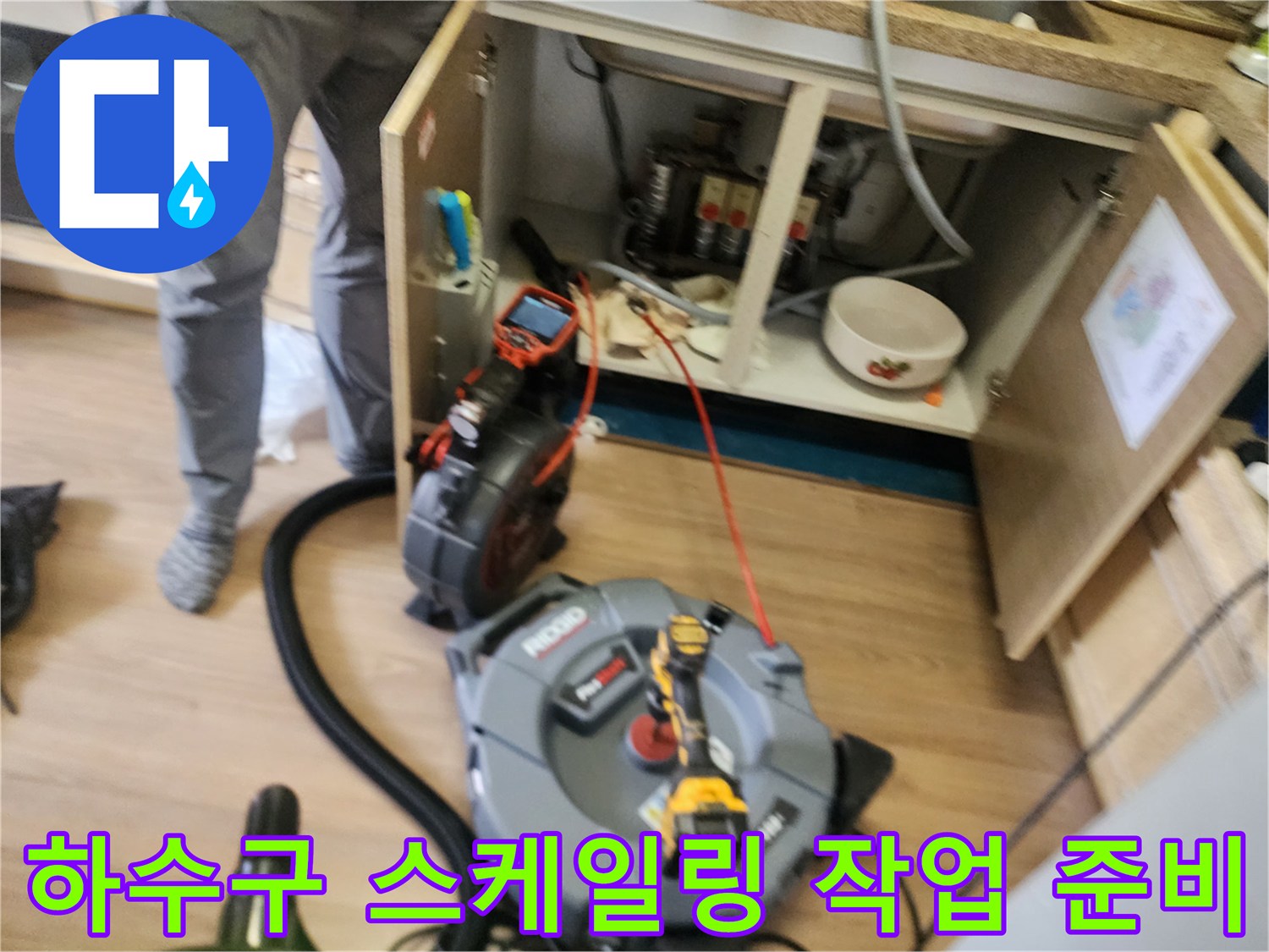 싱크대 하부장 내부의 배관 점검 및 장비 배치 모습
