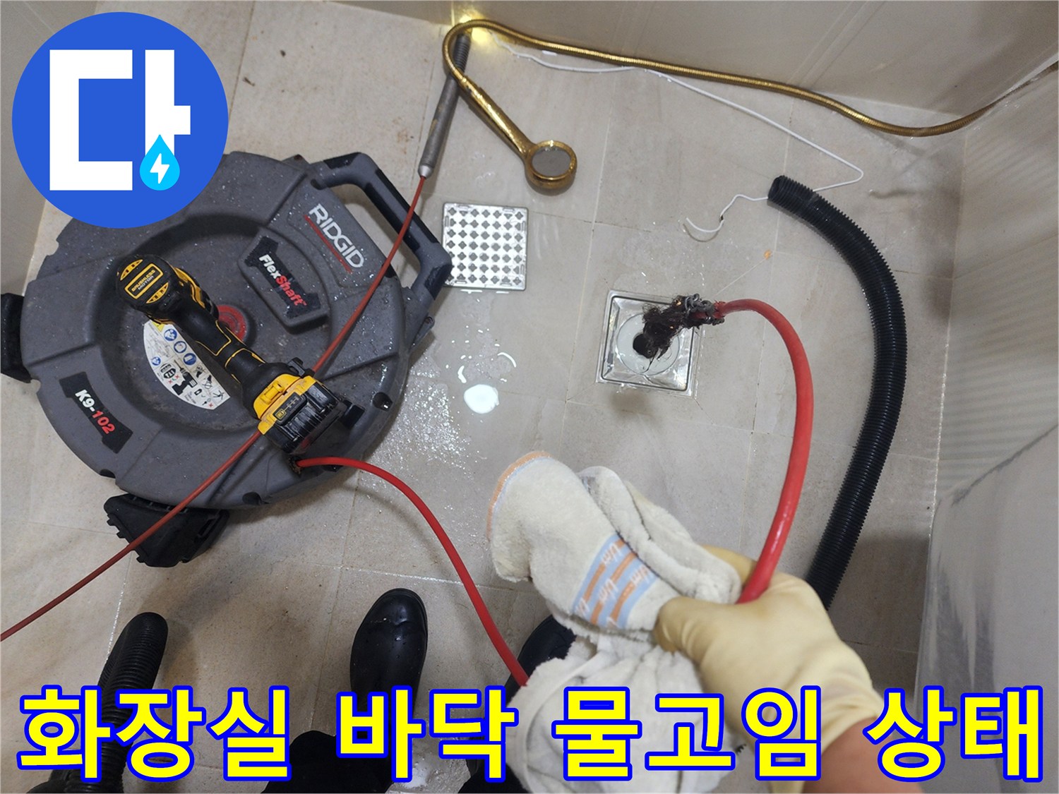 물기가 남아있는 화장실 타일 바닥과 배수구 주변의 스케일링 장비 연결선