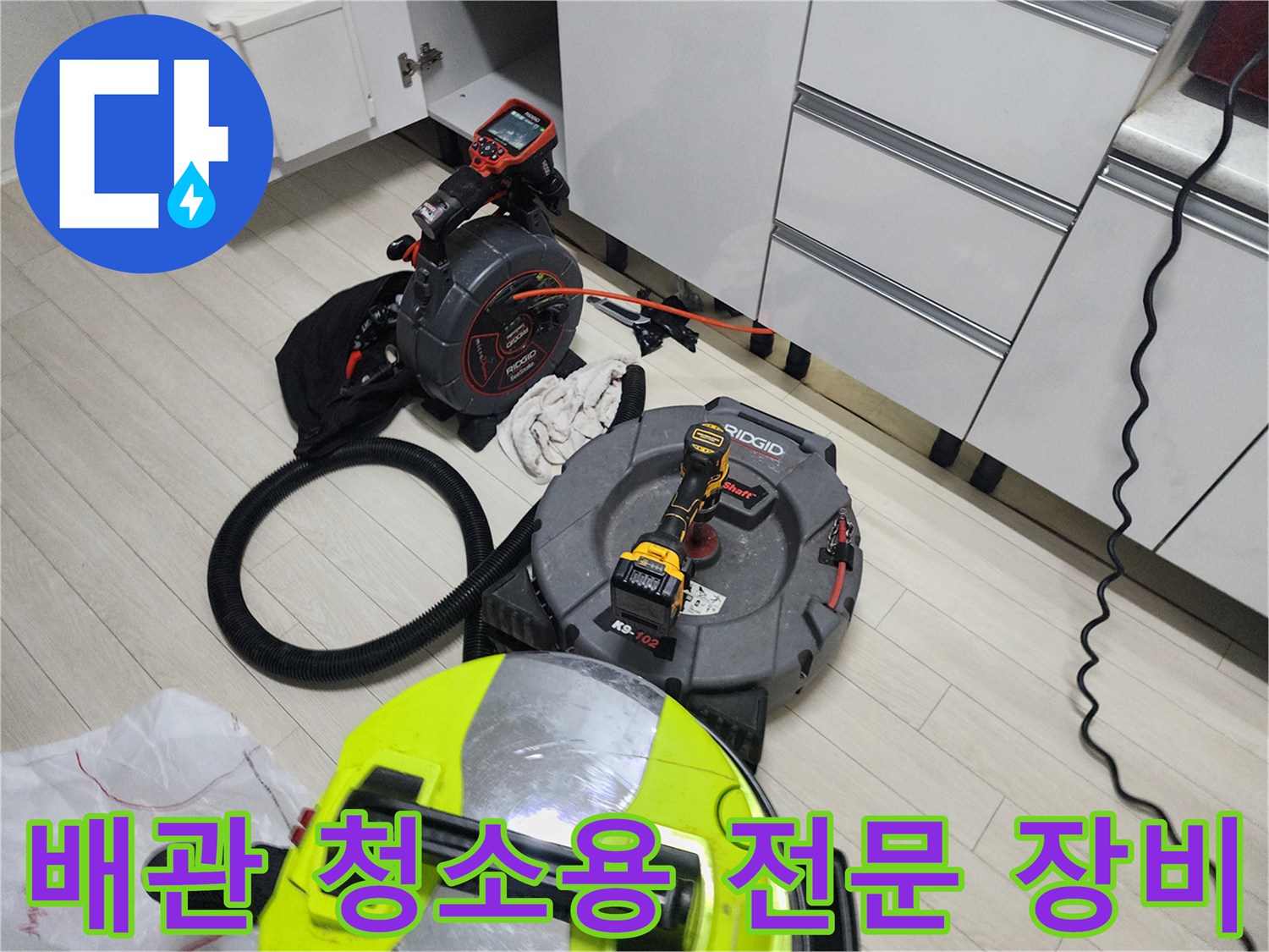 작업 공간에 배치된 배관 스케일링기와 내시경 카메라 릴 세트