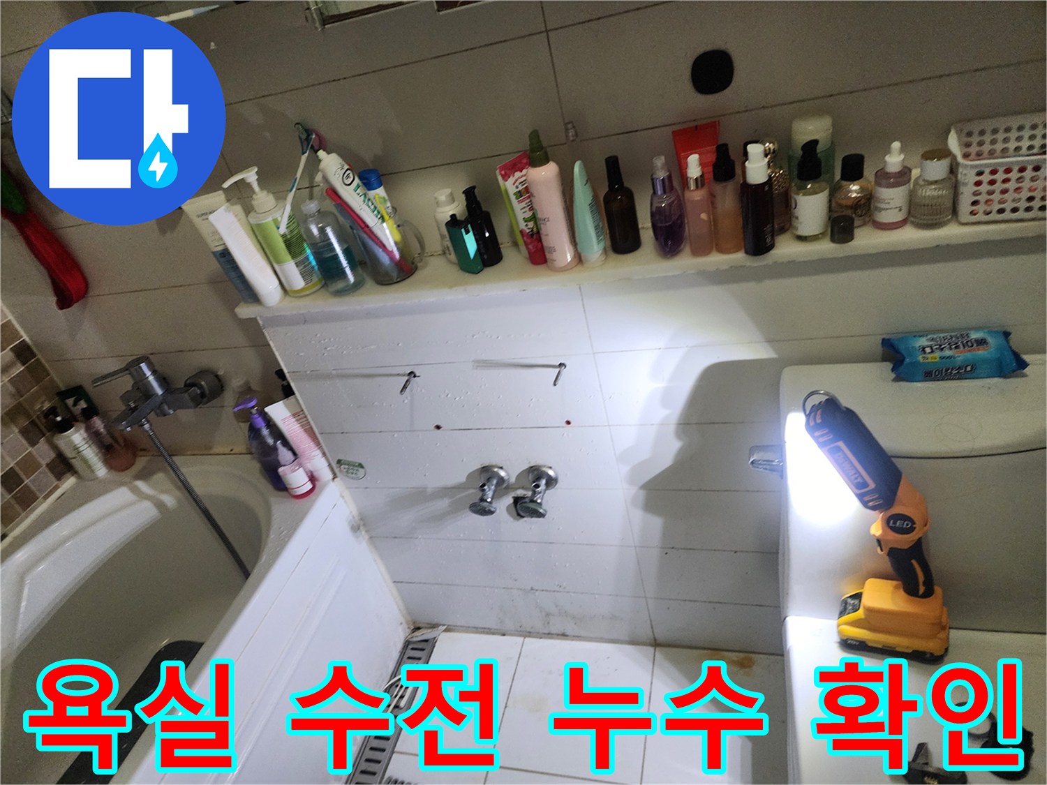 세면대 아래쪽 배관과 벽면 타일 틈새의 습기를 점검하는 작업 장면입니다.