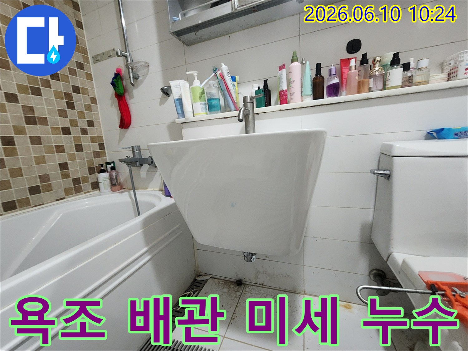 욕조 주변과-세면대 하부 바닥의-오염과 물기 흔적을 통해-오래된 욕조 배관의-미세 누수 가능성을-보여주는 현장 사진입니다