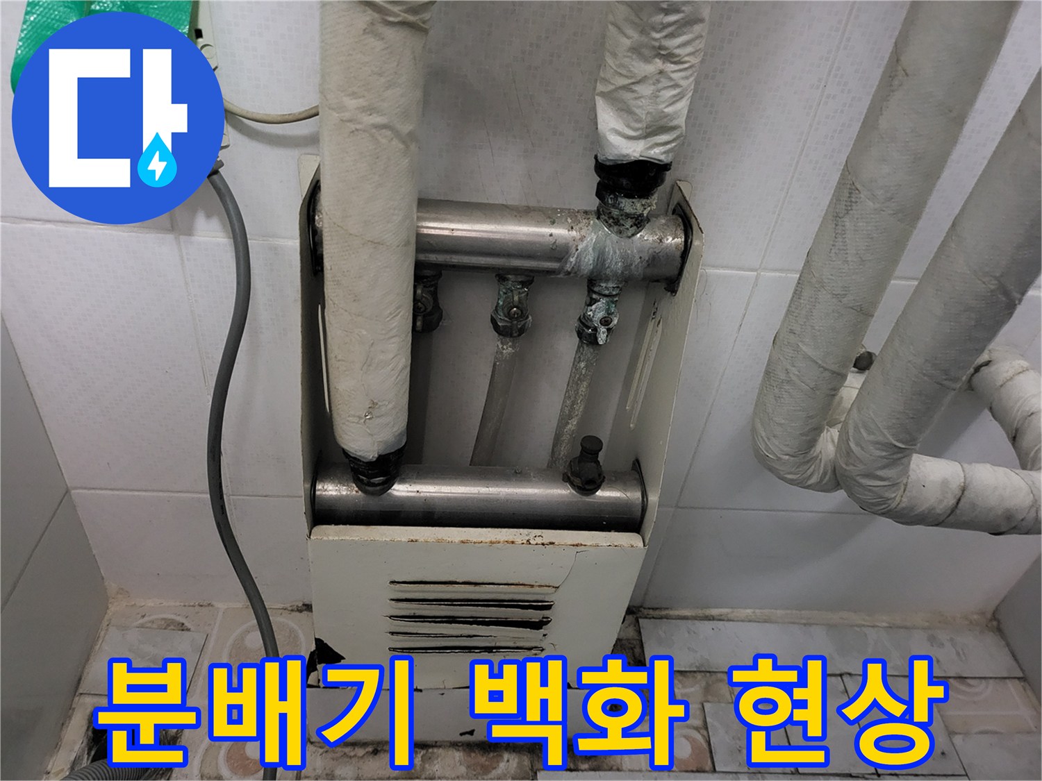 하얀 가루가 맺혀 있는 노후된 분배기 배관 연결부