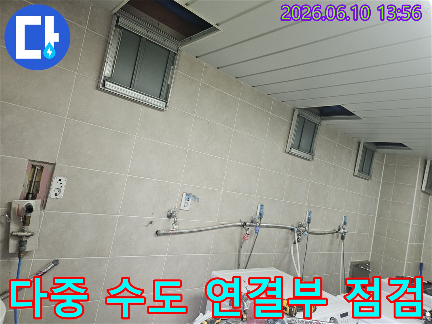 세탁실 벽면에 여러 개의 수도 연결부가 보이는-복잡한 배관 시스템을 체계적으로 점검하는-누수 탐지 현장