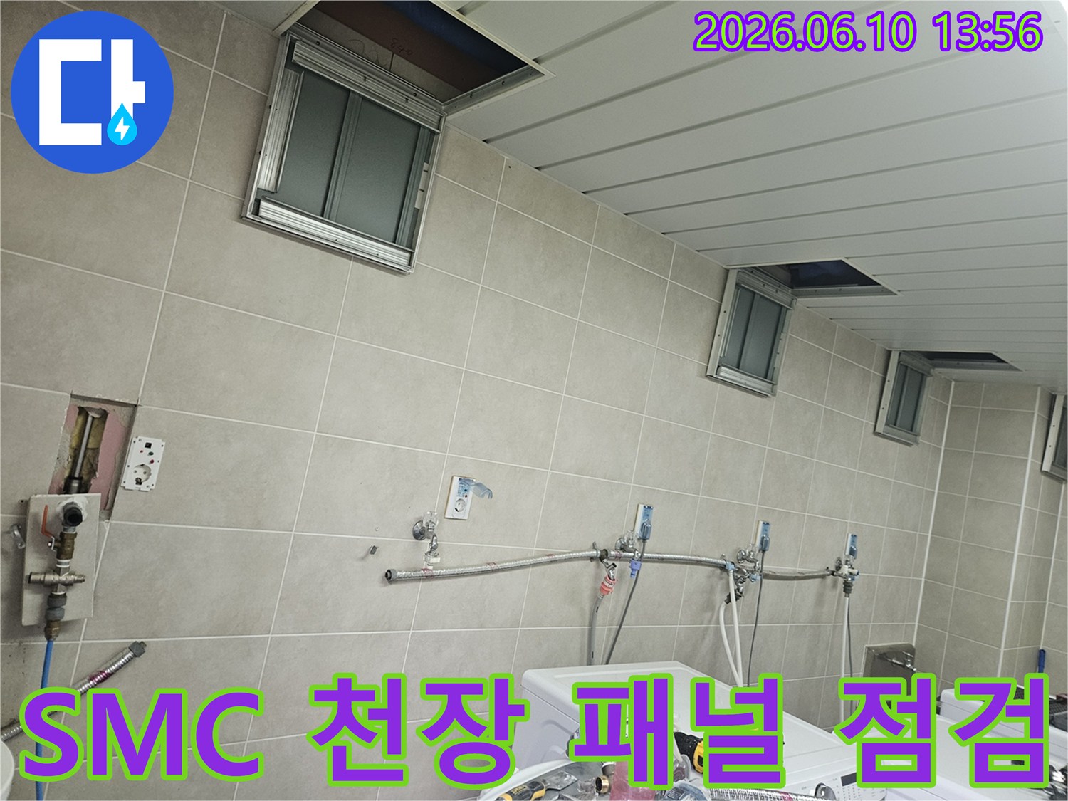 세탁실의 SMC 천장 패널이 열린 상태에서-누수 흔적과 패널 손상 여부를 확인하는-정밀 점검 과정