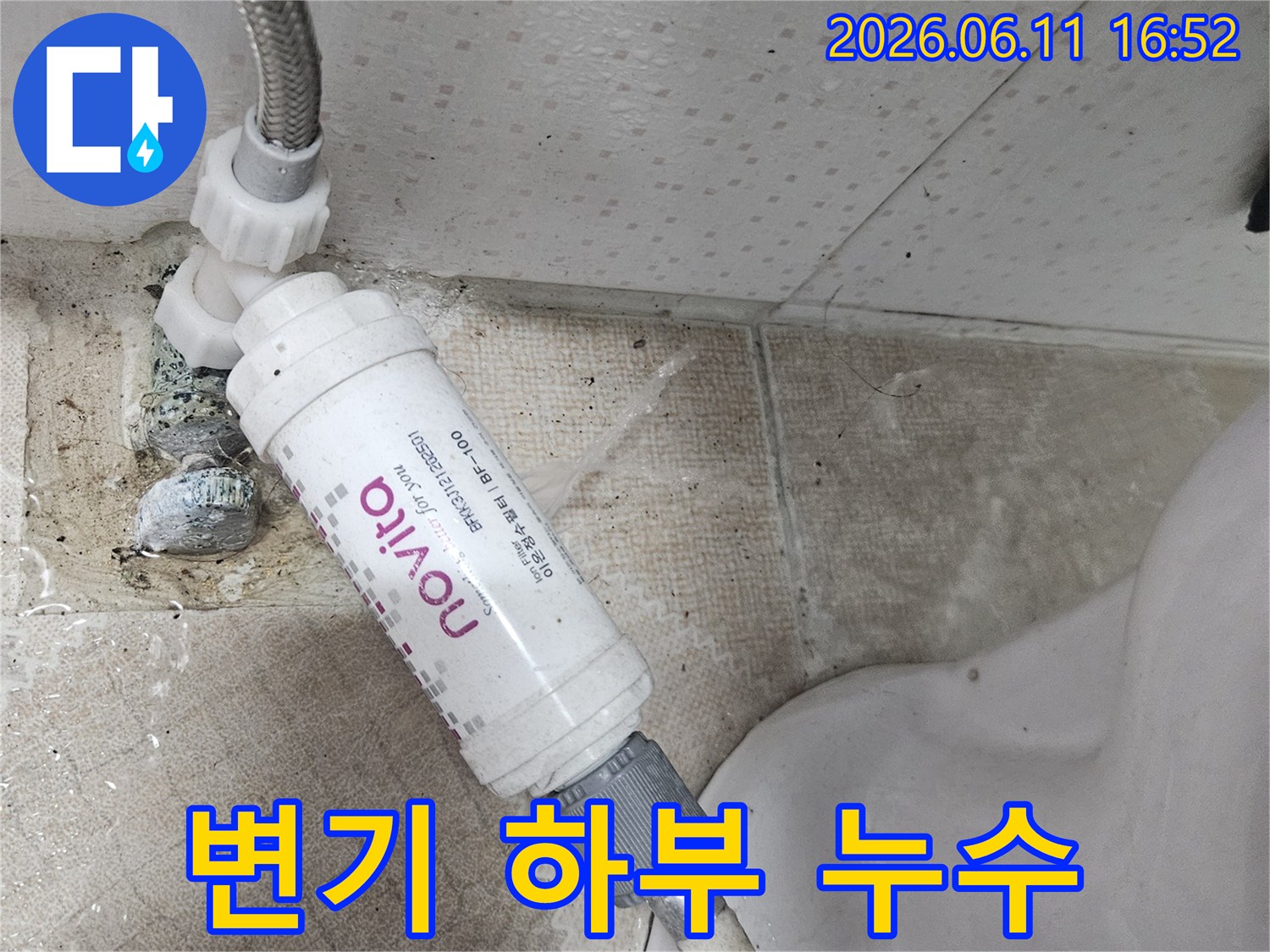 변기 옆에 설치된 정수 필터에서-물이 새어 나와-바닥을 적시고 있는-누수 현장을 보여주는 이미지