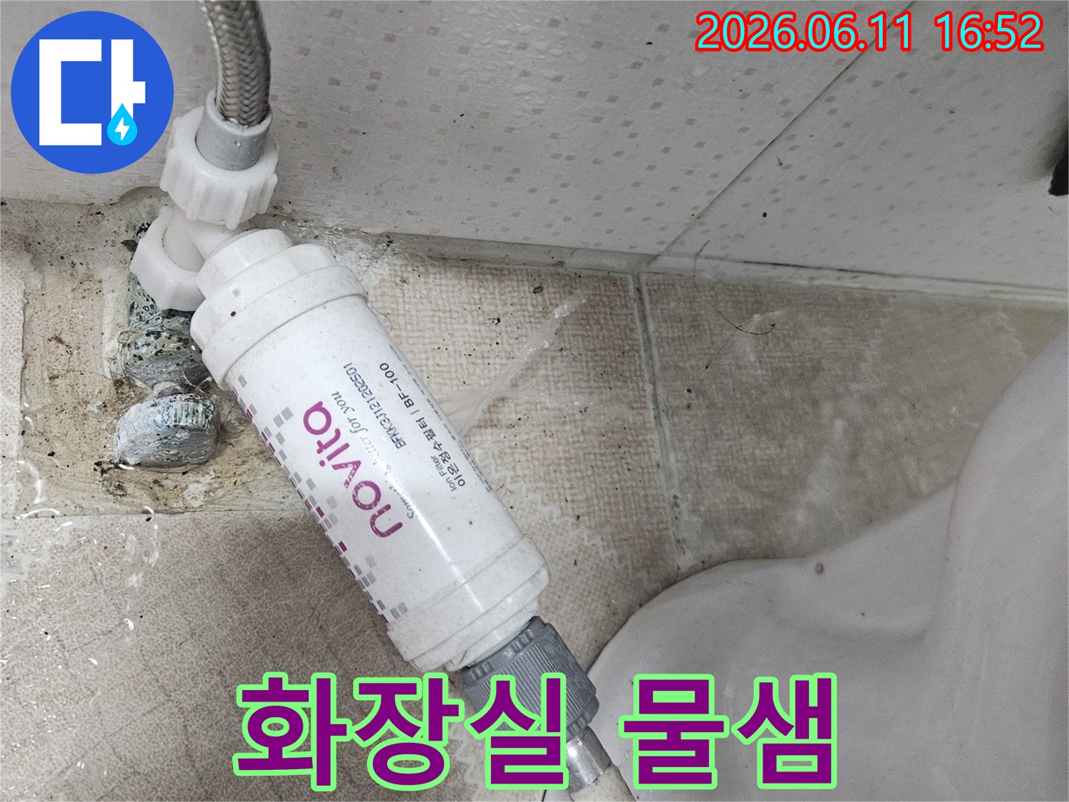 욕실 바닥으로 물이 흐르는-변기 하단부의-수도 연결 필터 누수 상황을 보여주는 사진