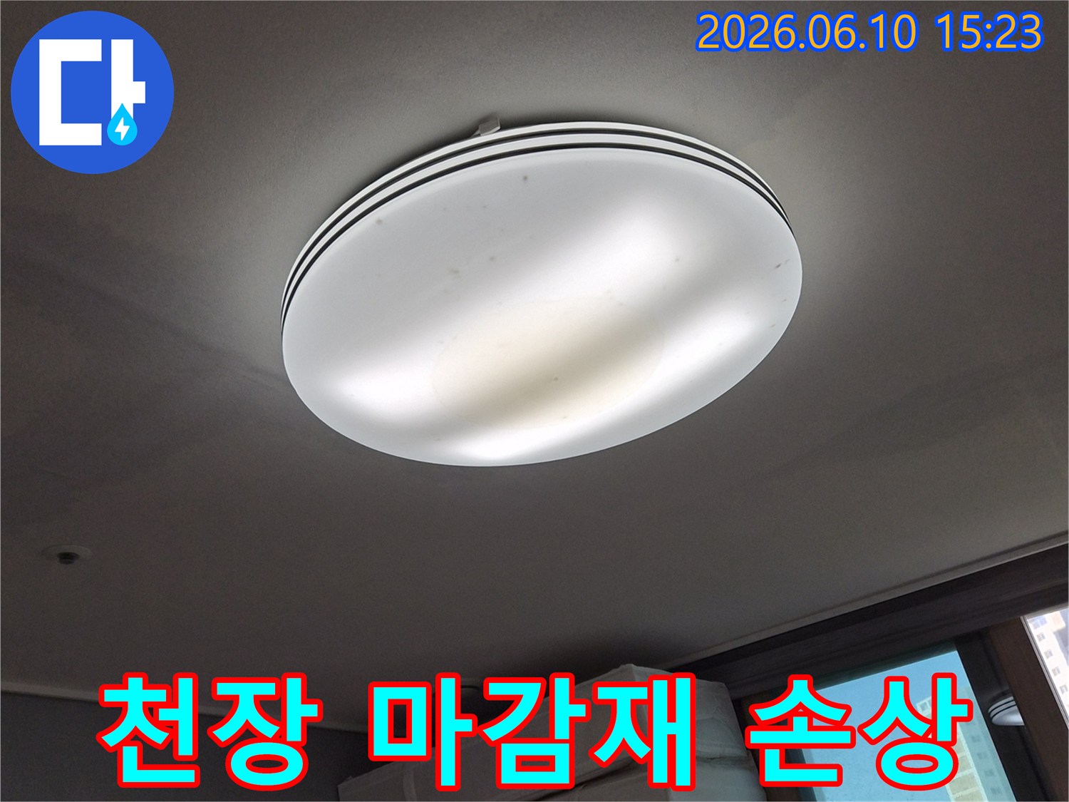 누수로-인해-천장 마감재가-손상되고-변색된-조명 주변의-모습을-보여주는-사진입니다