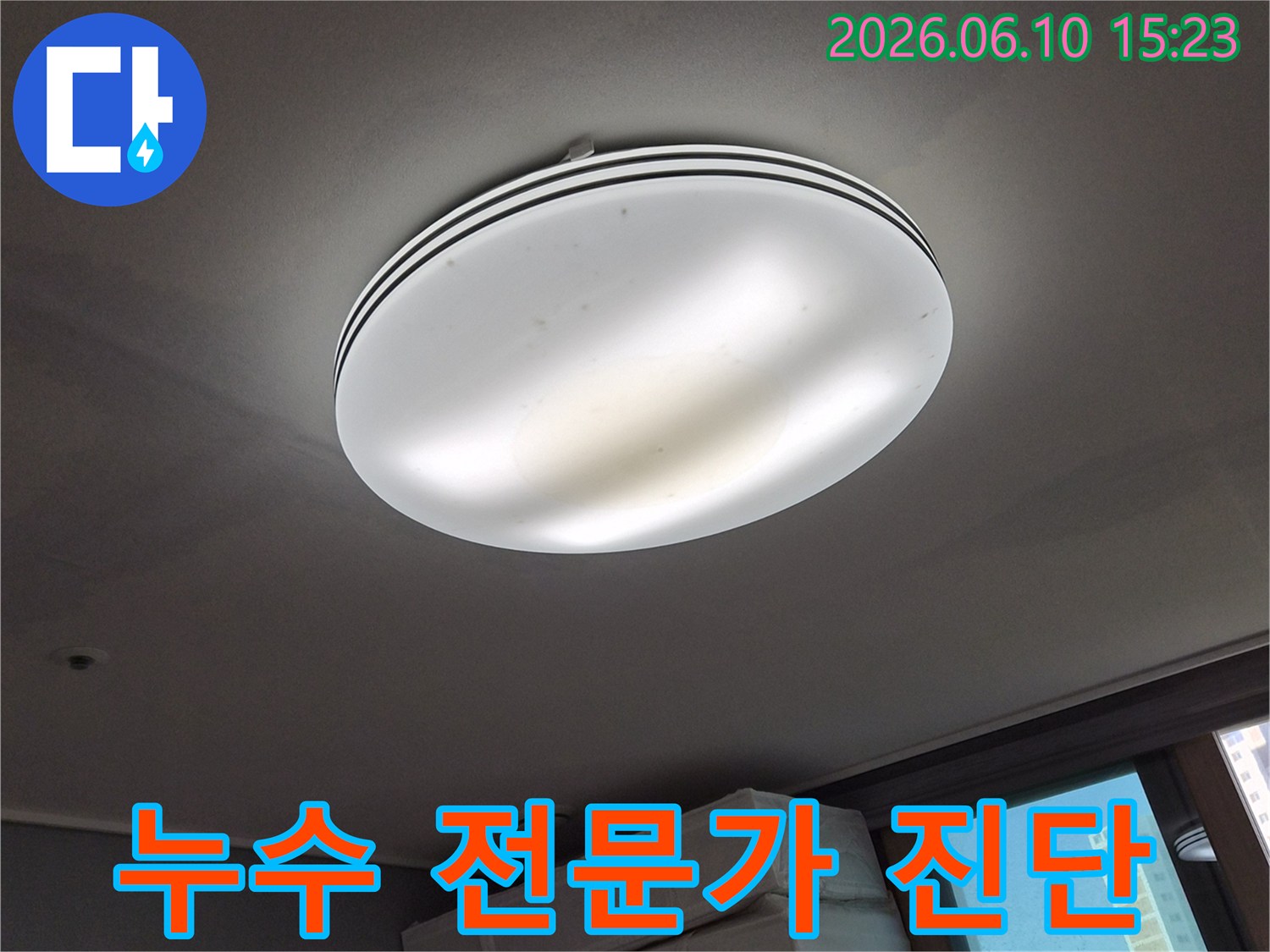 천장 조명 주변의-누수 흔적을-누수 전문가가-꼼꼼하게-진단하는-모습을-보여주는-사진입니다