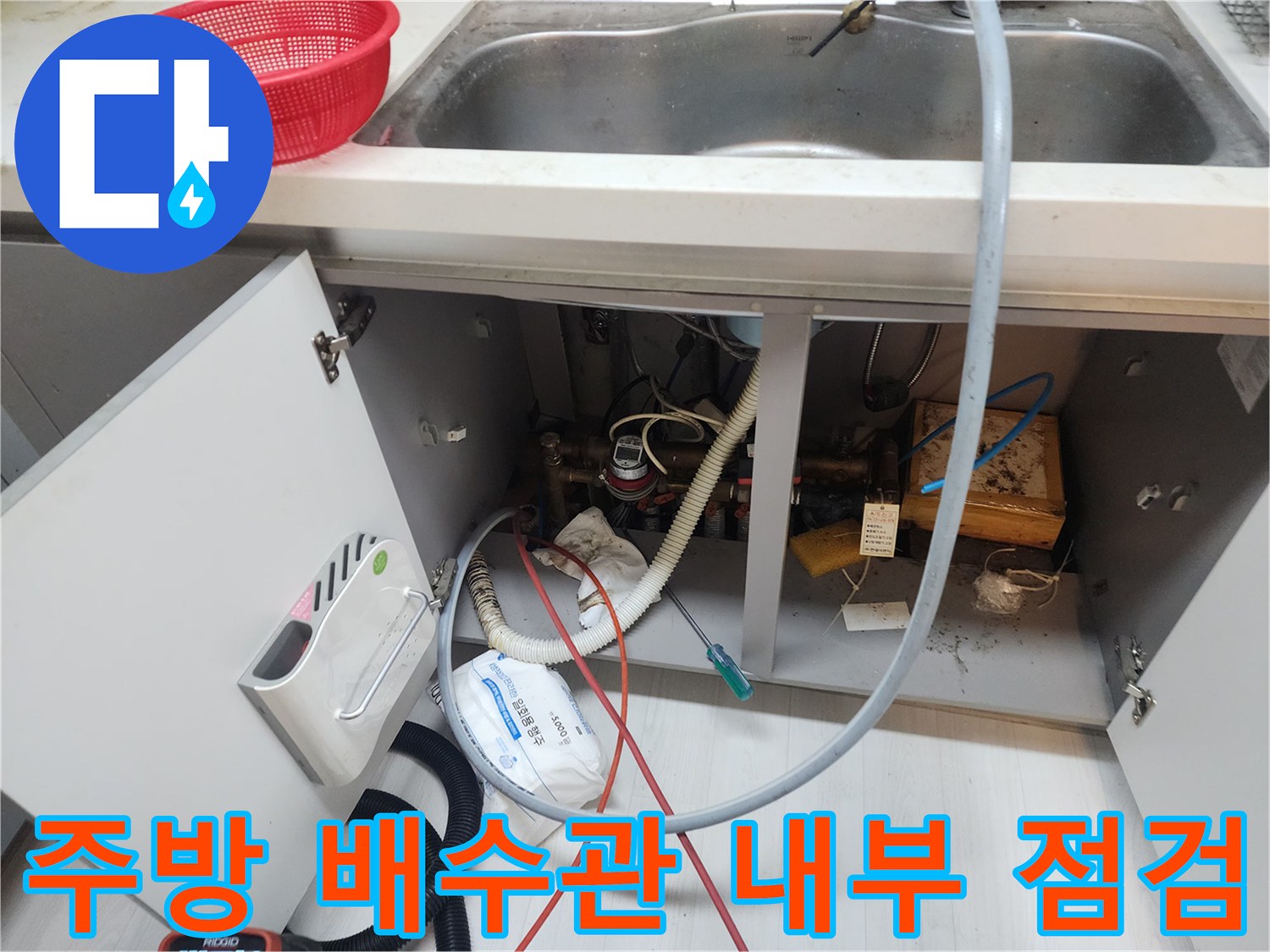 복잡한 구조의 주방 배수 호스와 연결된 하수관 점검 사진입니다.