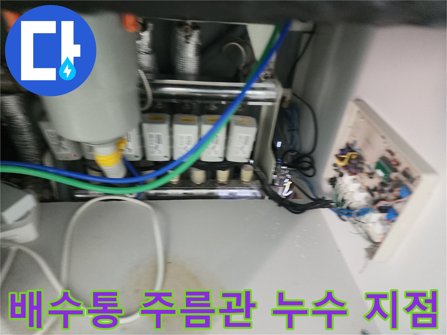 싱크대 하단 배수통과 주름관 사이에서 물이 새어 나오는 장면 - 누수 부위 포착