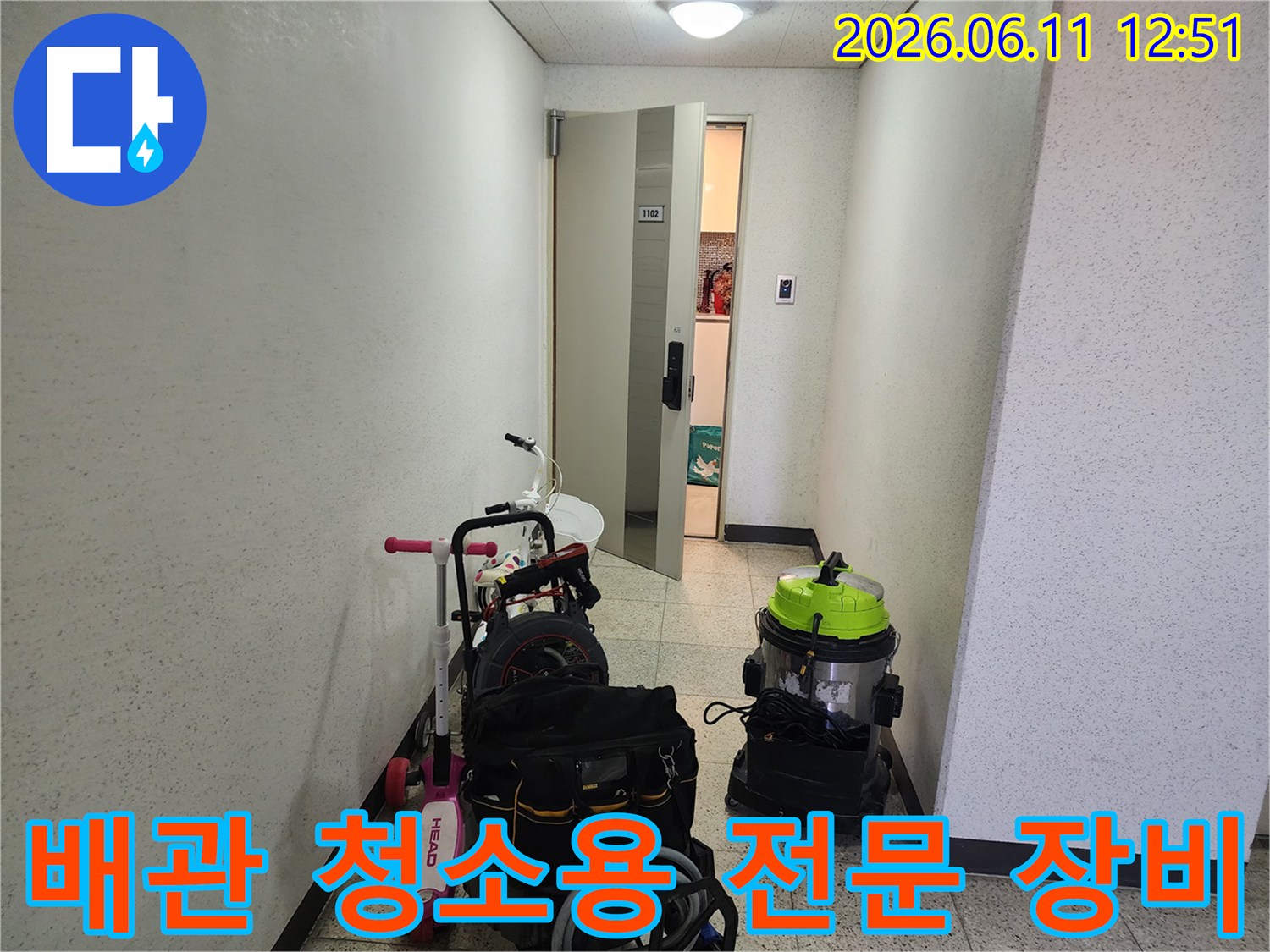 복도에 놓인 배관 세척용 진공 흡입기와 작업용 가방 모습입니다.