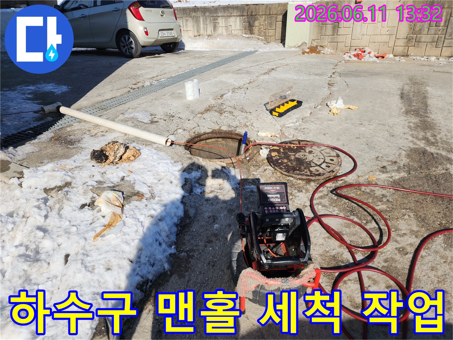 맨홀 뚜껑과-고압 호스가 연결된 하수도 배관 작업 현장
