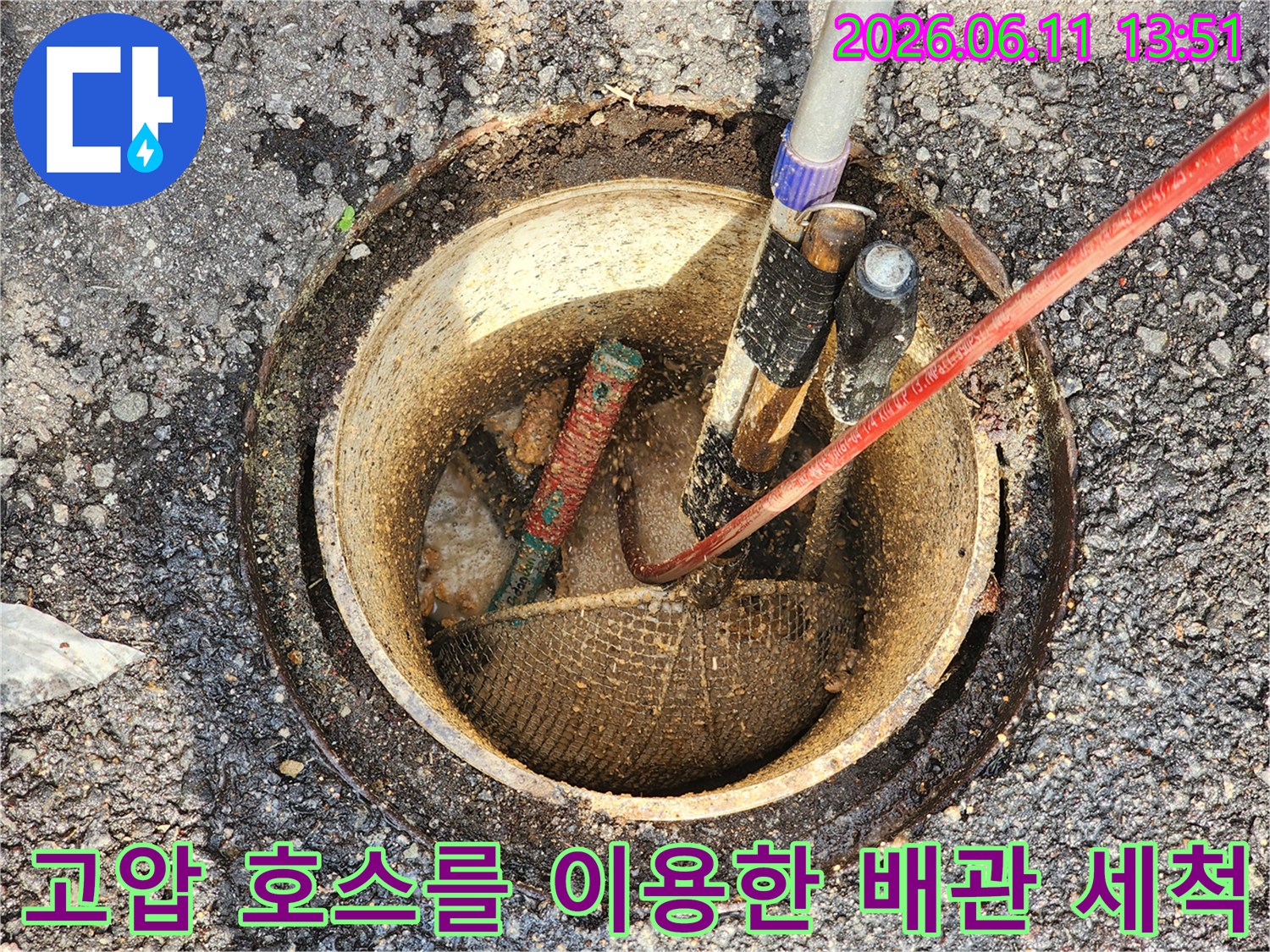 맨홀 내부에 설치된 배관과 고압 세척용 호스가 연결되어 작업 중인 모습입니다.